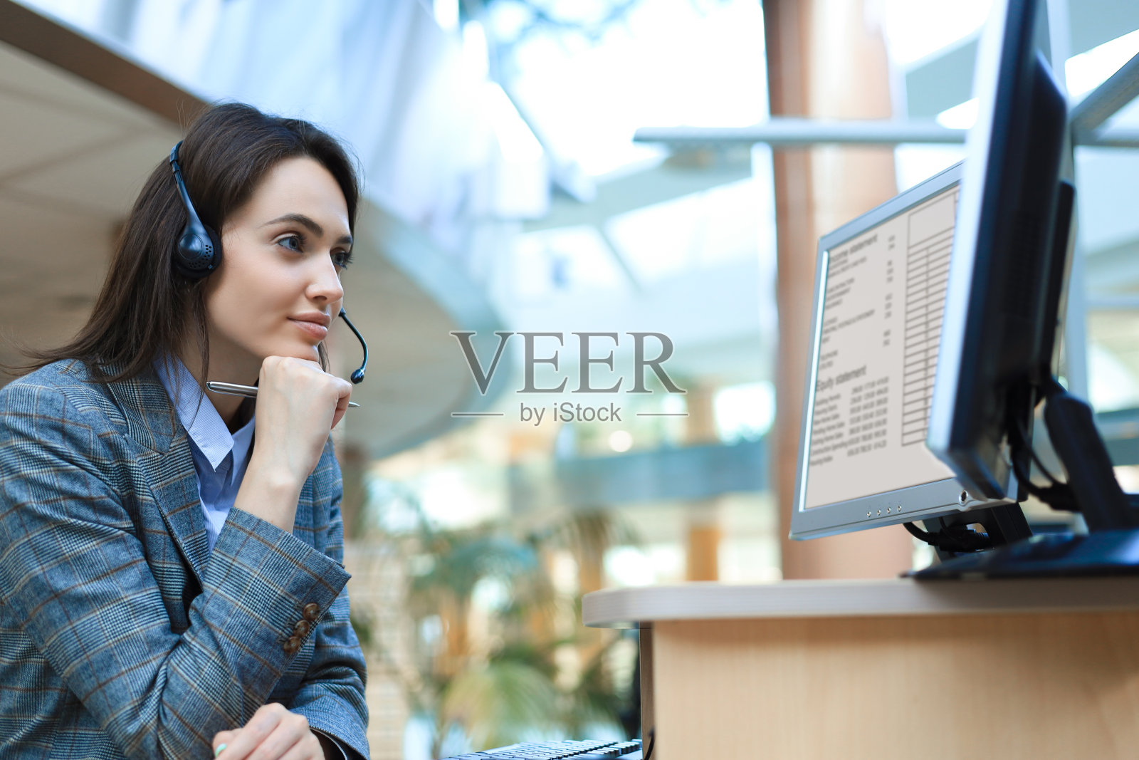 女客服人员，头戴耳机，面带微笑。照片摄影图片