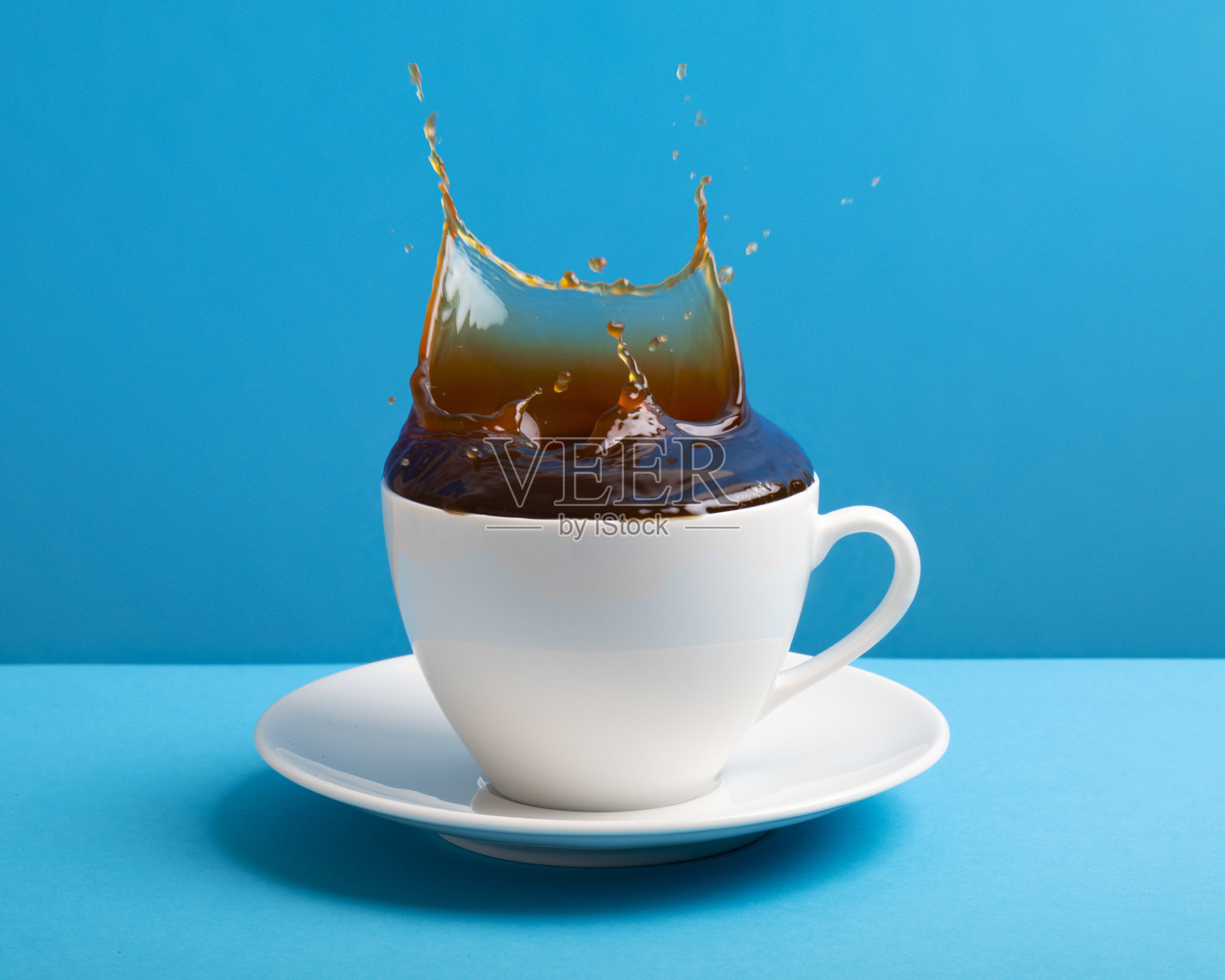 白色咖啡杯，蓝色咖啡喷溅照片摄影图片
