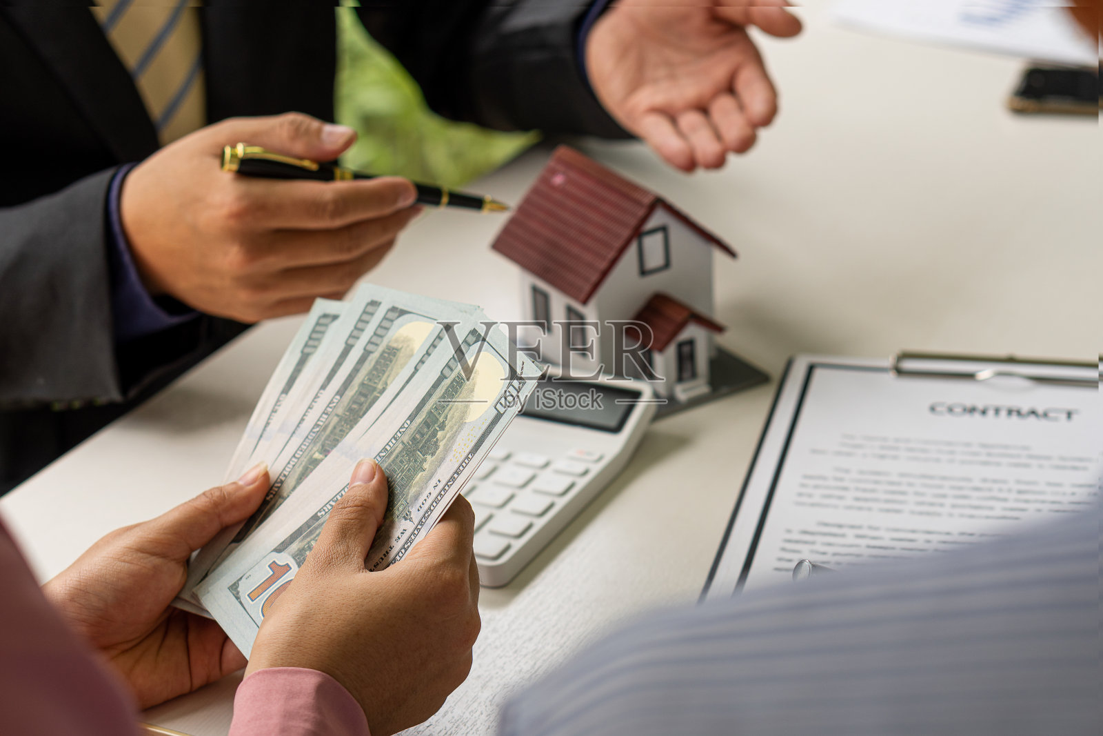 经销商提供购房合同或讨论贷款和利率。新房主在签约买房或租房时就有了办公桌、工作空间、购房租房的想法。照片摄影图片