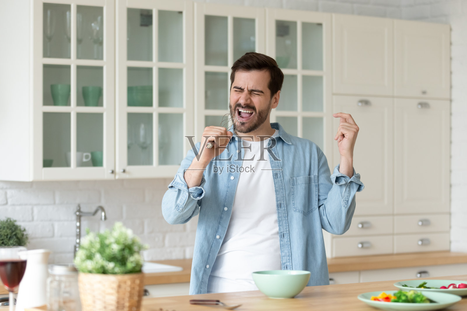 男人捧着whisk唱歌享受新的一天和最喜爱的爱好照片摄影图片