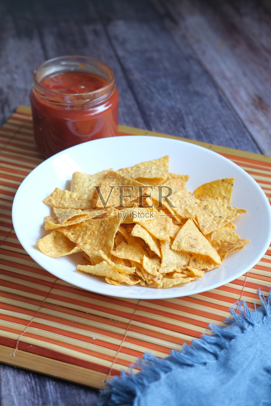 桌上放着一碗薯条和辣酱，照片摄影图片