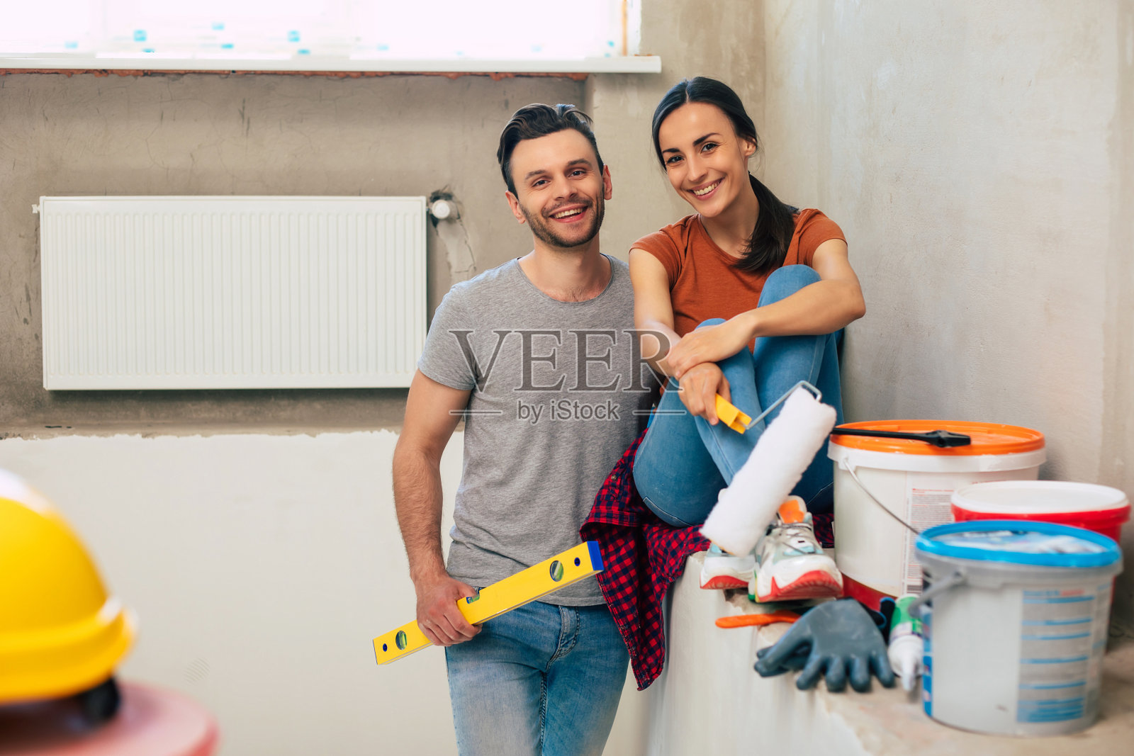 现代恋爱中的幸福青年情侣在新居装修或装修墙壁期间用了很多工具来做这件事照片摄影图片