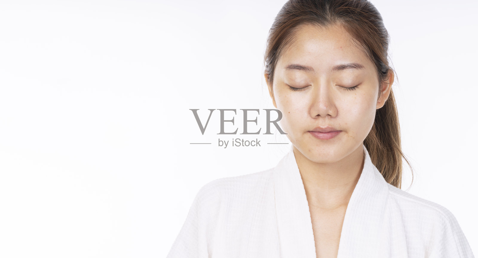 美丽的年轻女子没有化妆在她的脸上没有修饰，新鲜的脸，而看着相机在孤立的白色背景。面部治疗、美容、水疗、化妆、美容外科诊所概念。照片摄影图片