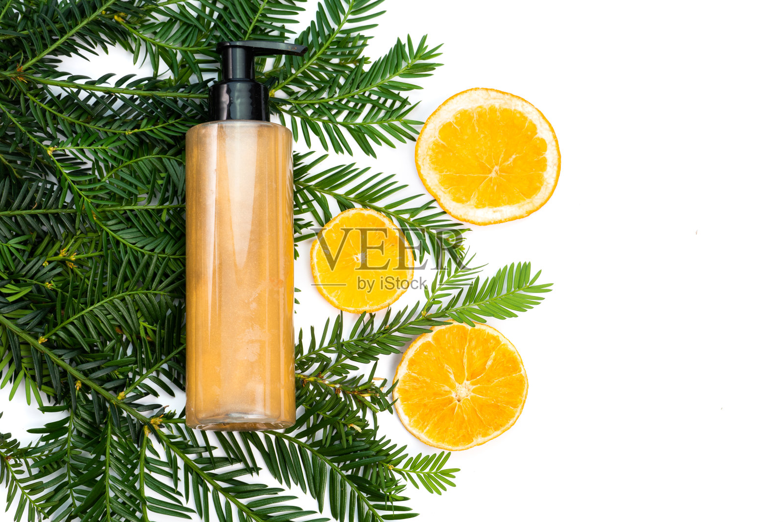 化妆品平铺:古铜色的身体闪光膏，多汁的橘片和绿色的小枝在白色的背景上照片摄影图片