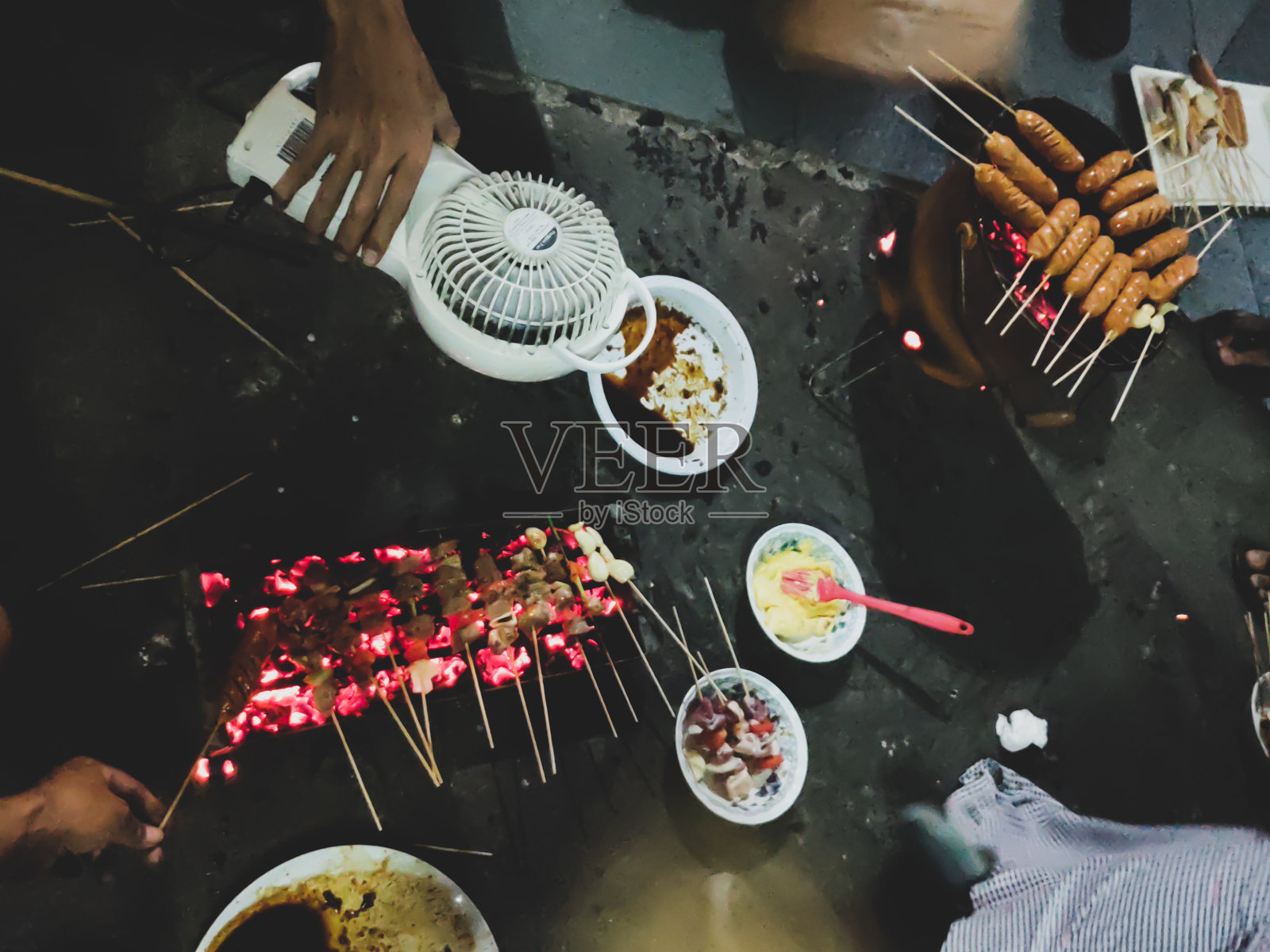 人们在烤沙嗲牛肉和香肠照片摄影图片