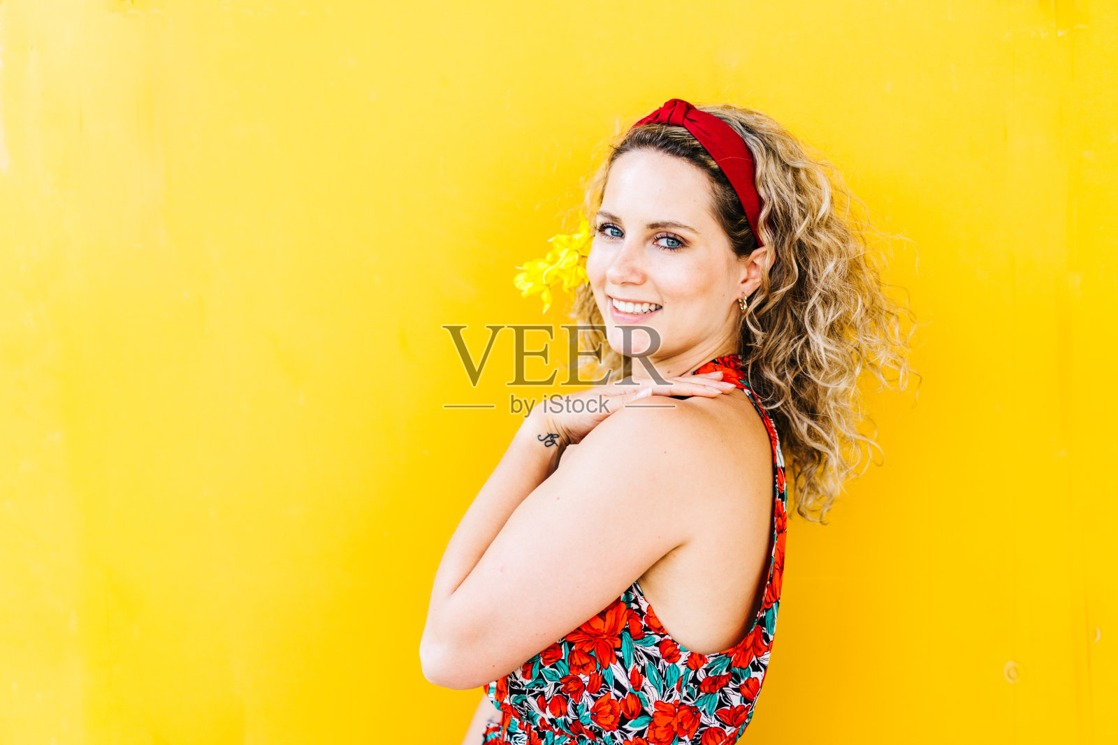 一个炎热的夏天，黄色背景下的微笑女人的肖像照片摄影图片