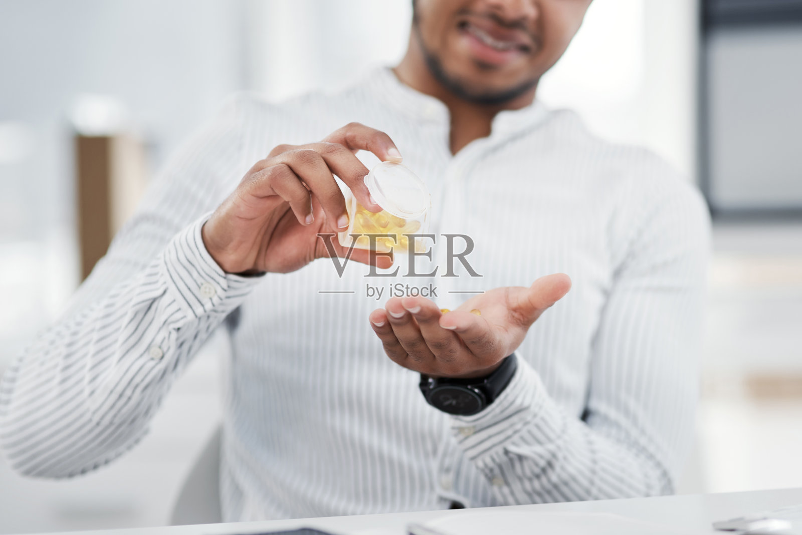 特写镜头:一个在办公室里把药丸倒进手里的商人照片摄影图片