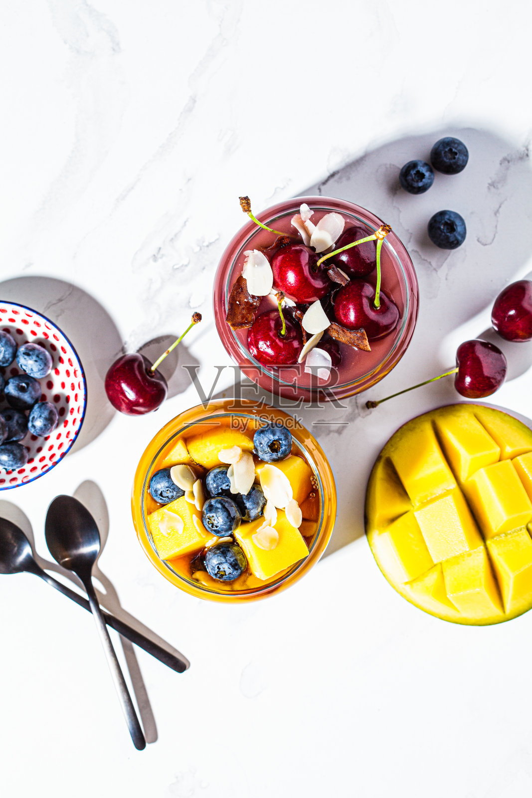 芒果和浆果冰沙罐子，俯视图。健康食品理念，素食早餐。照片摄影图片