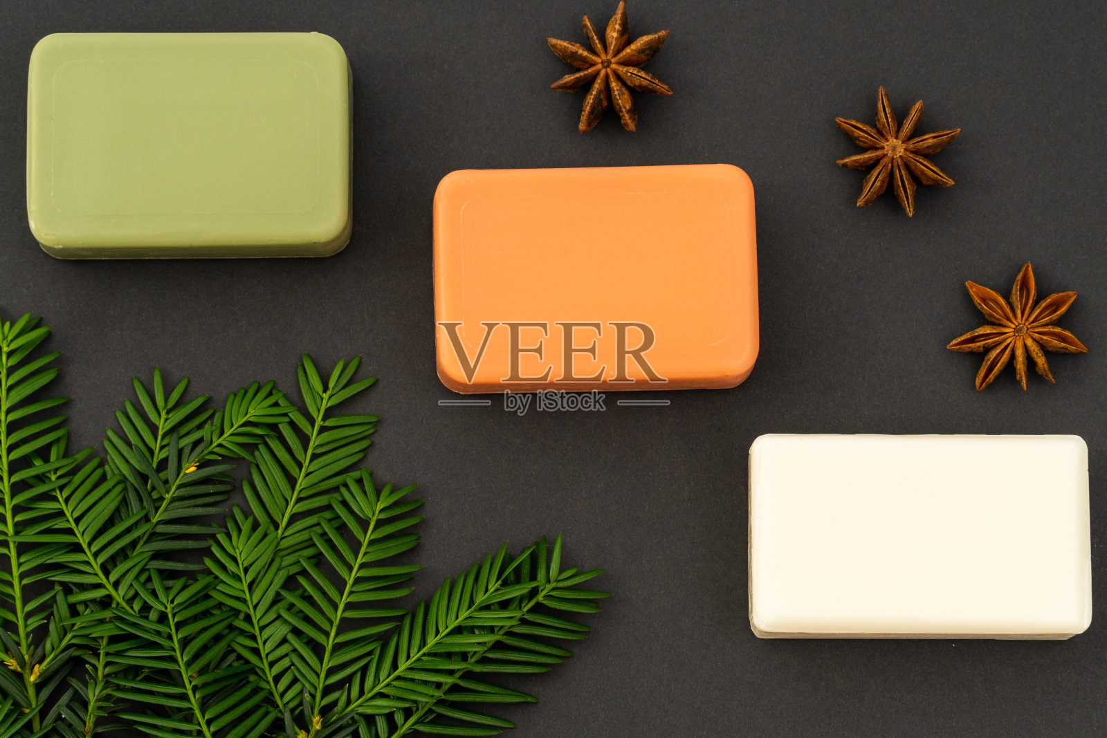 化妆平铺:白色、绿色和红色的手工皂，在灰色的背景上加上自然元素照片摄影图片