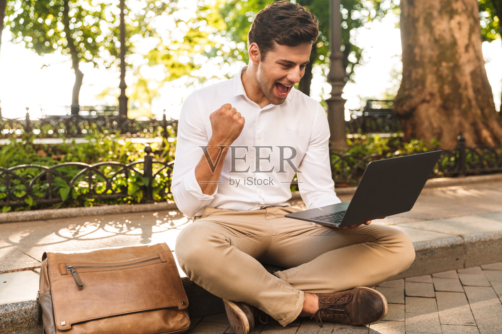 兴高采烈的年轻商人坐在户外照片摄影图片