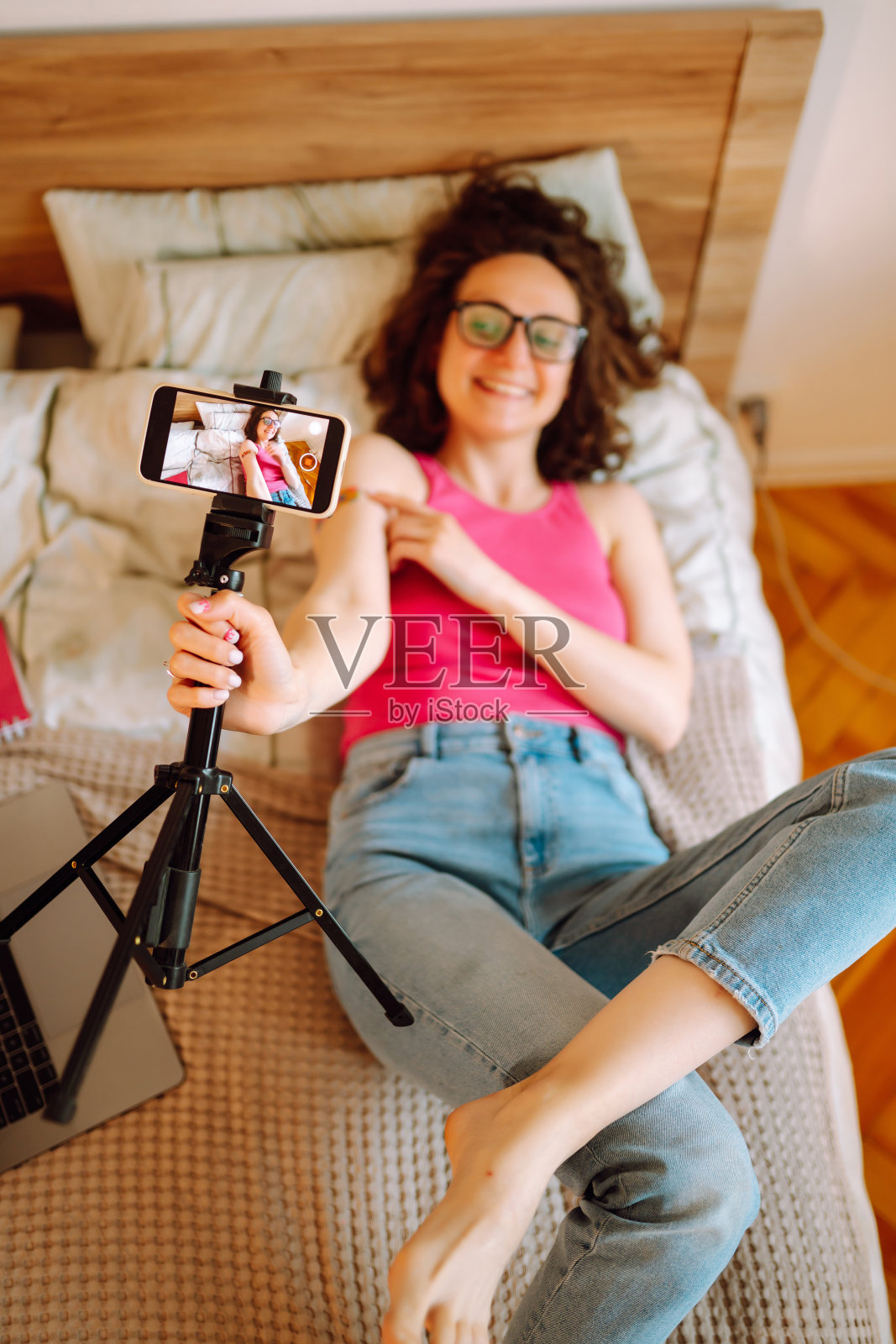 人们接种疫苗是为了免疫健康。一名女性博主在家中录制视频，谈论covid-19疫苗。照片摄影图片