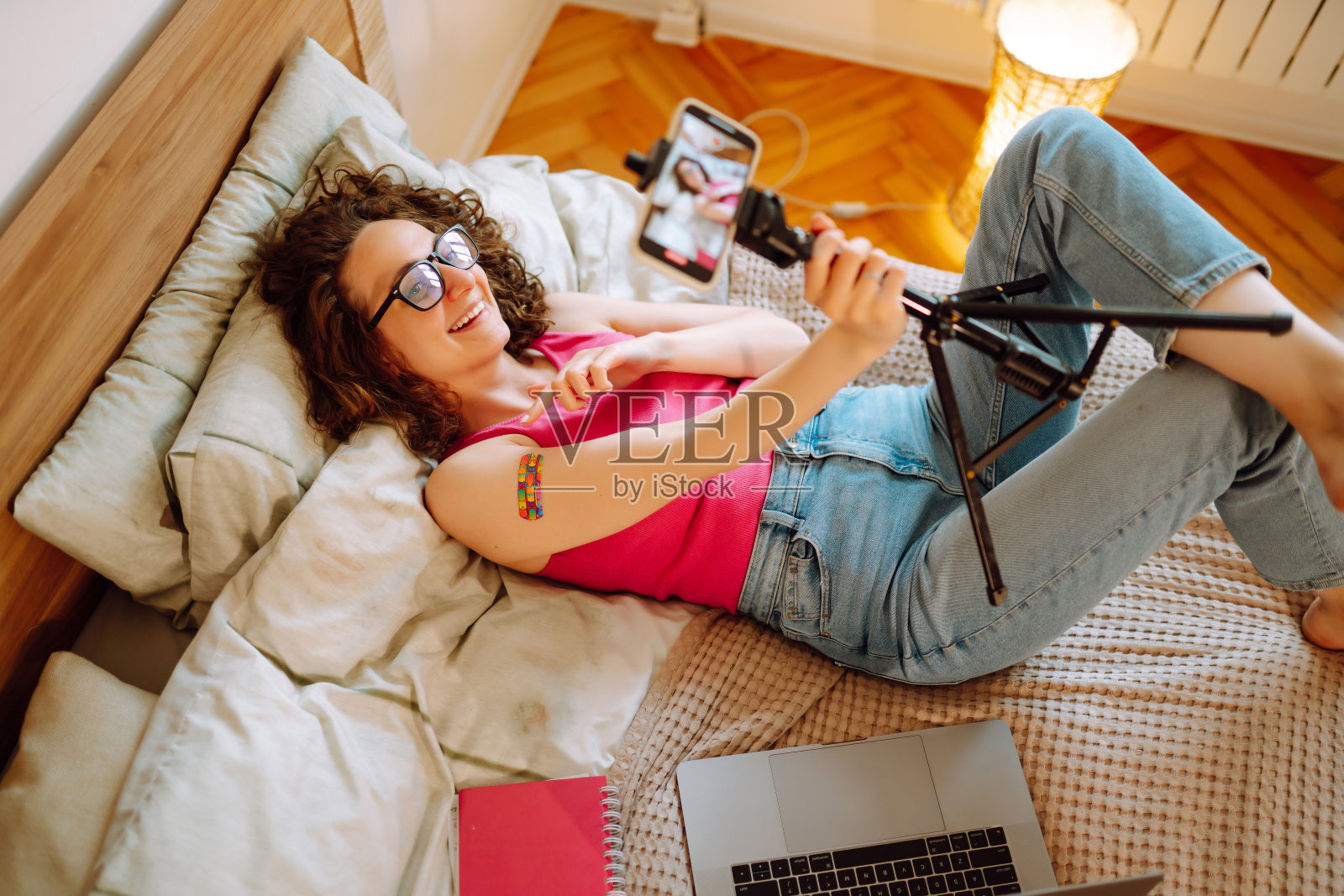 人们接种疫苗是为了免疫健康。一名女性博主在家中录制视频，谈论covid-19疫苗。照片摄影图片