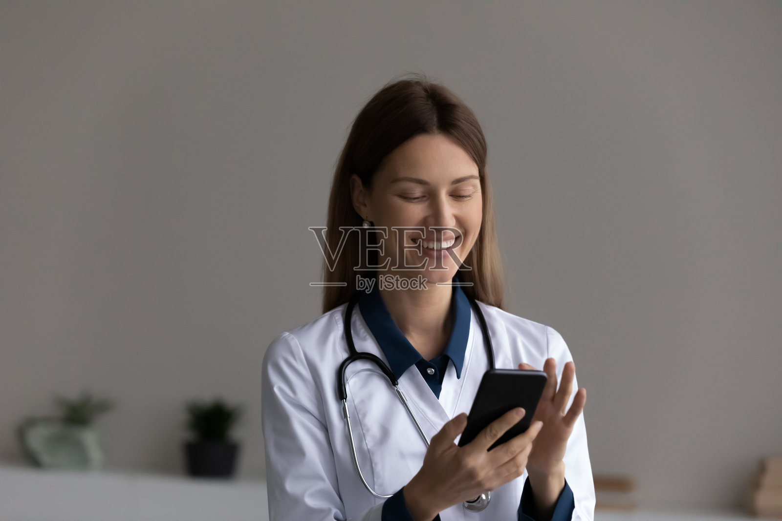 快乐的女医生用手机app预约照片摄影图片