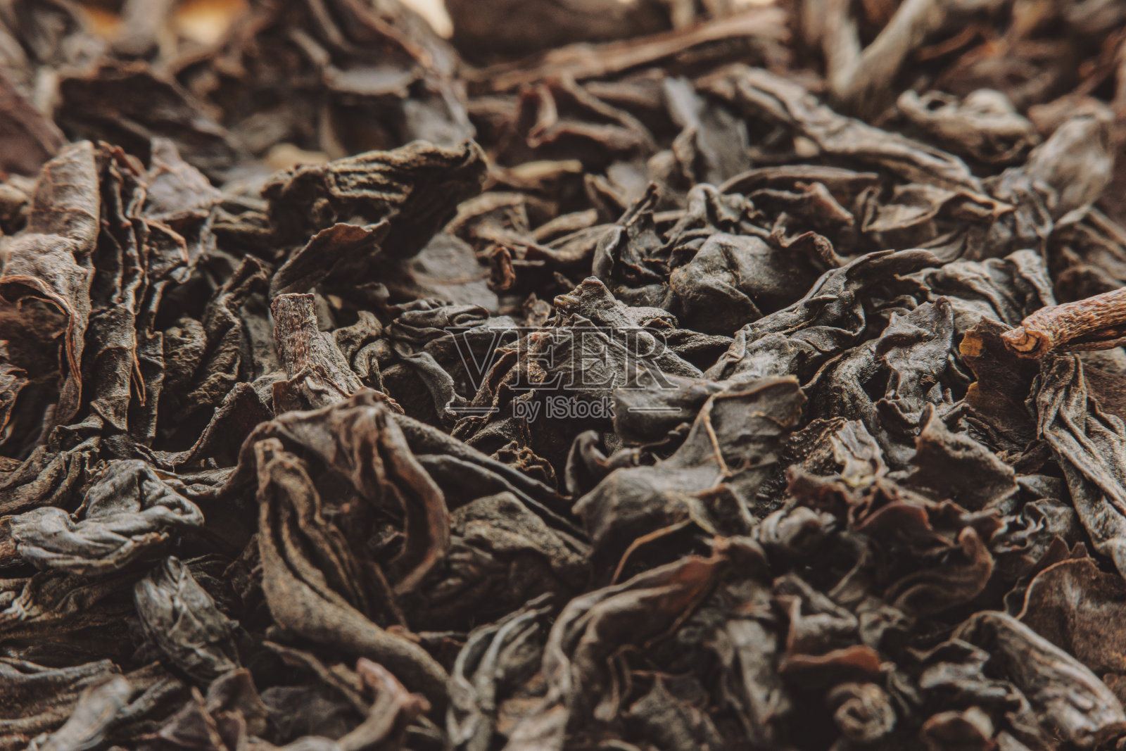 特写一堆干红茶茶叶在软焦点在高倍放大。干燥植物用于配制传统饮料。照片摄影图片