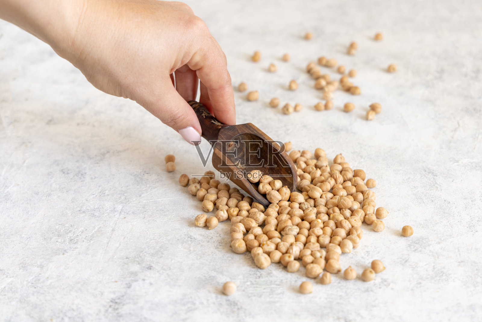 女人的手拿着鹰嘴豆勺照片摄影图片