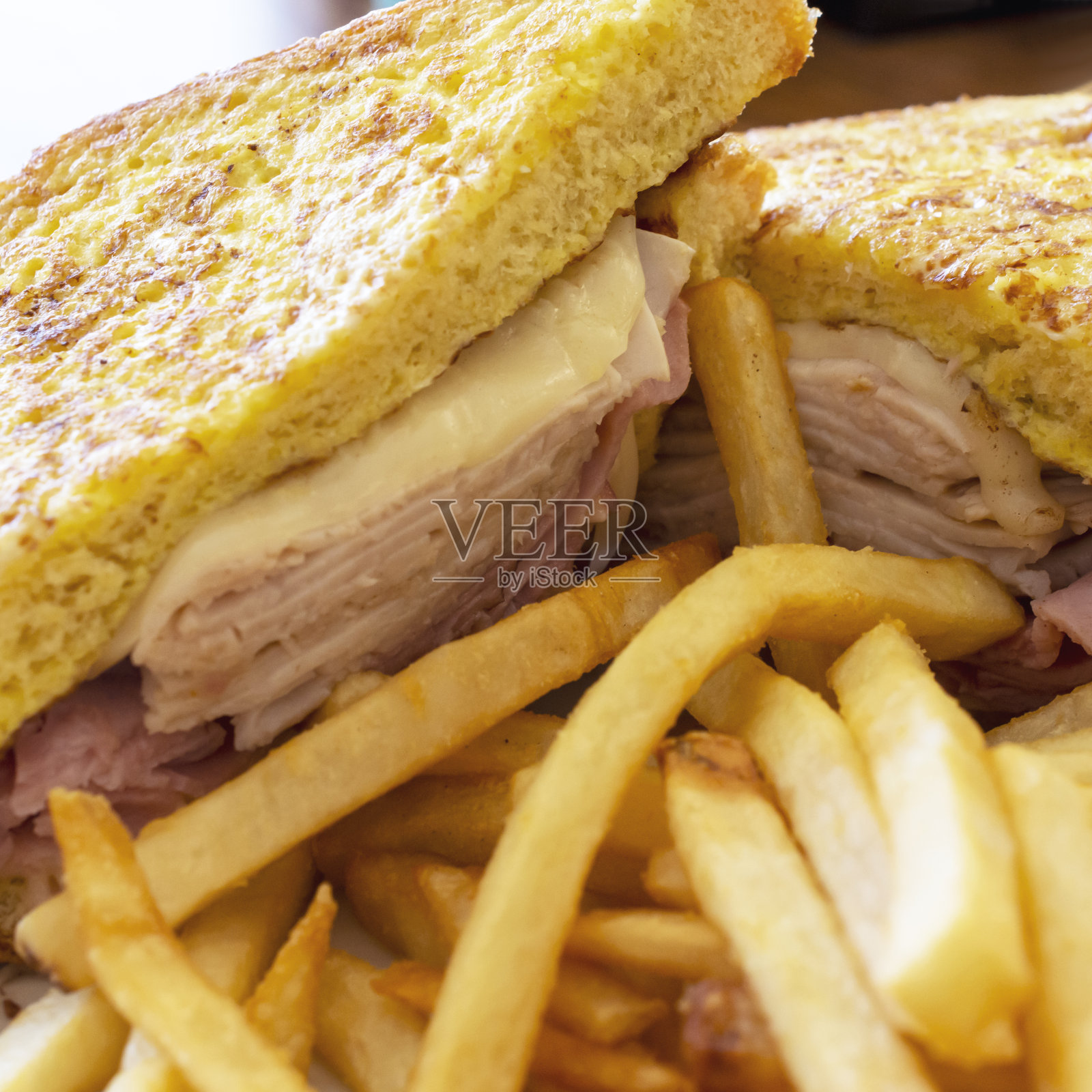 在一家小餐馆里，一个基督山三明治放在一个白色的盘子里。照片摄影图片