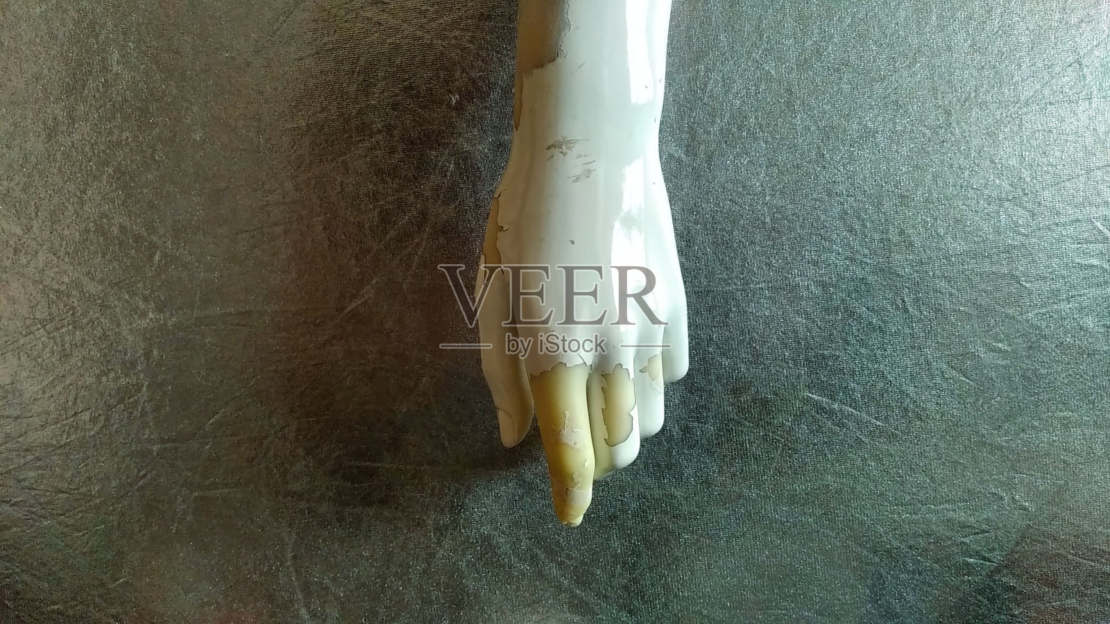 古老和风化的女性的瓷器手与损坏的手指人体模型，在一个黑暗的平面背景照片摄影图片