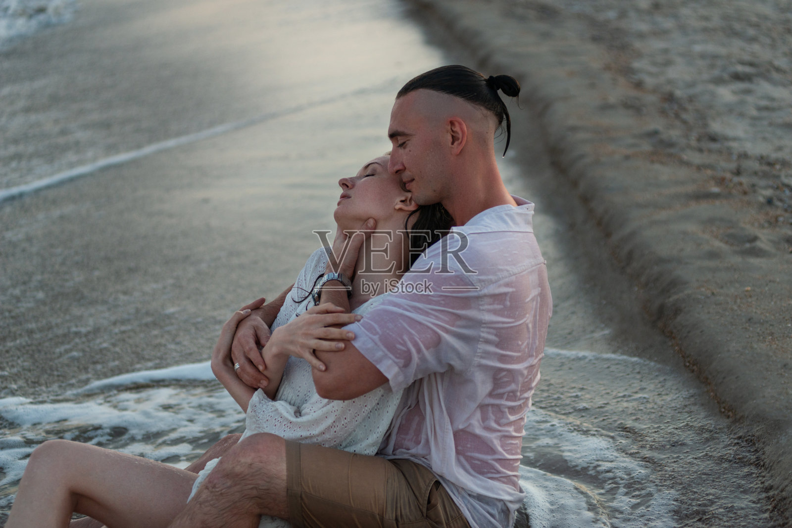 幸福的情侣在日落时分的海边漫步照片摄影图片