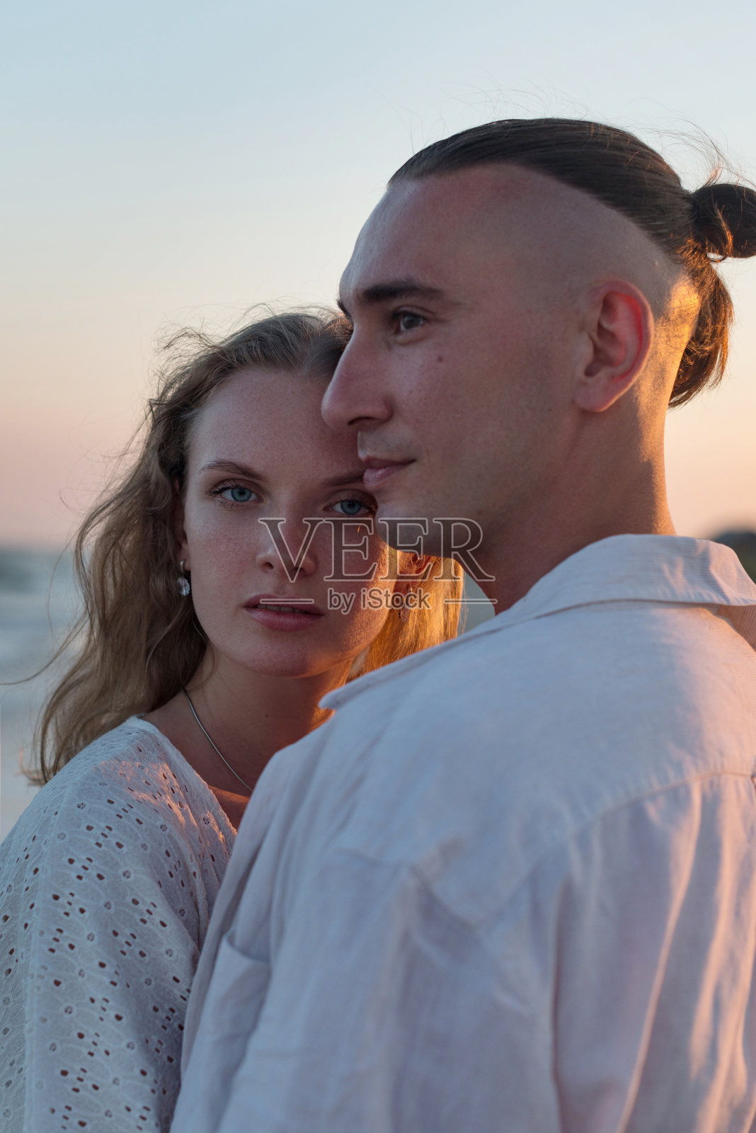 幸福的情侣在日落时分的海边漫步照片摄影图片