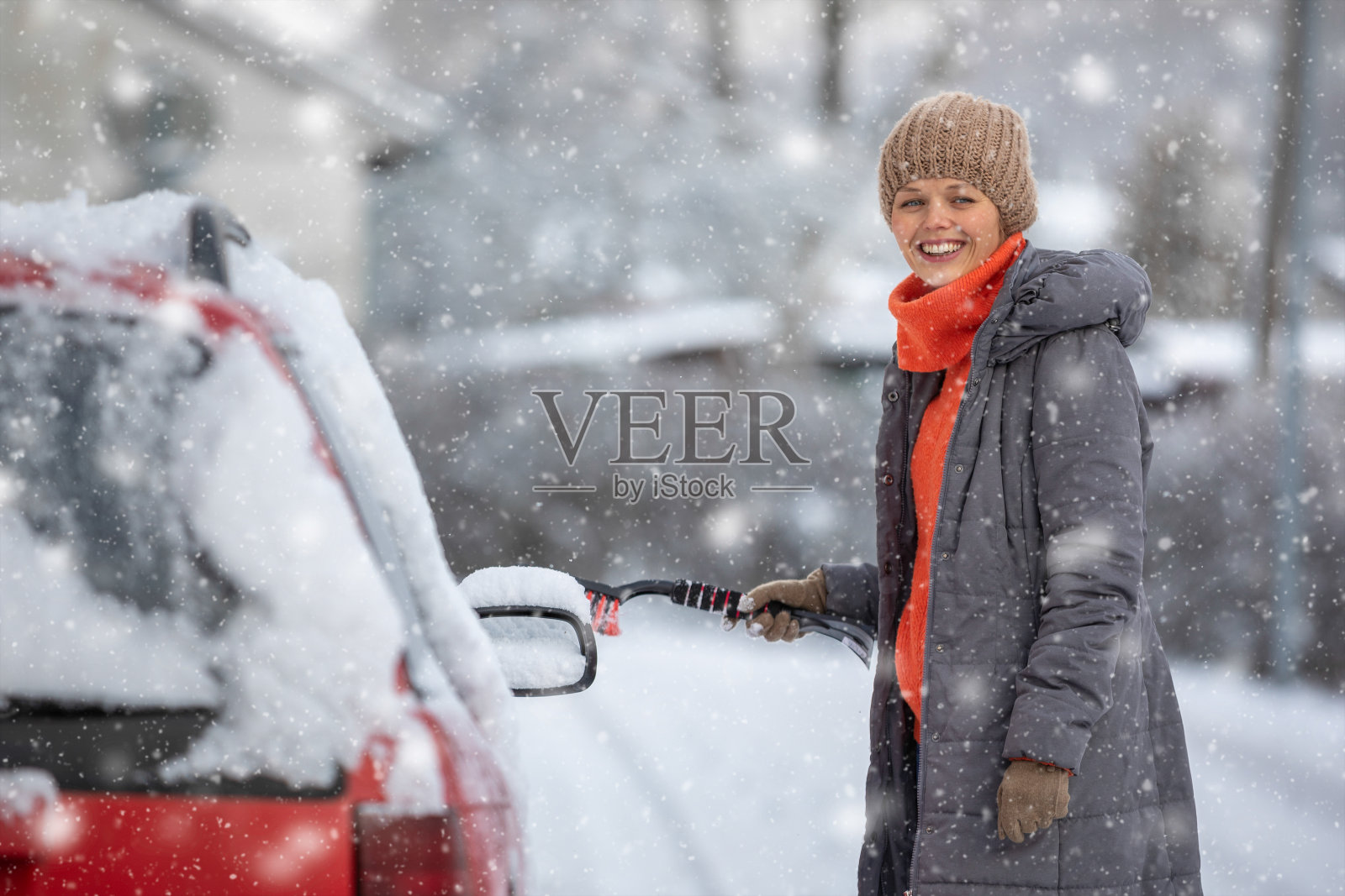 年轻漂亮的女人正在清理积雪照片摄影图片