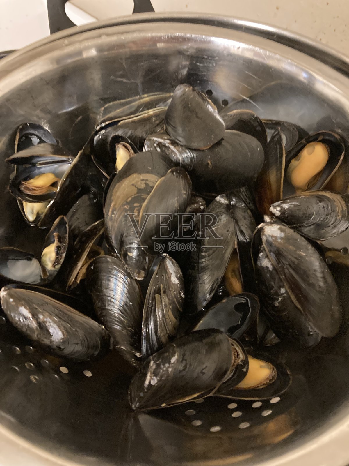 用滤网煮贻贝。照片摄影图片