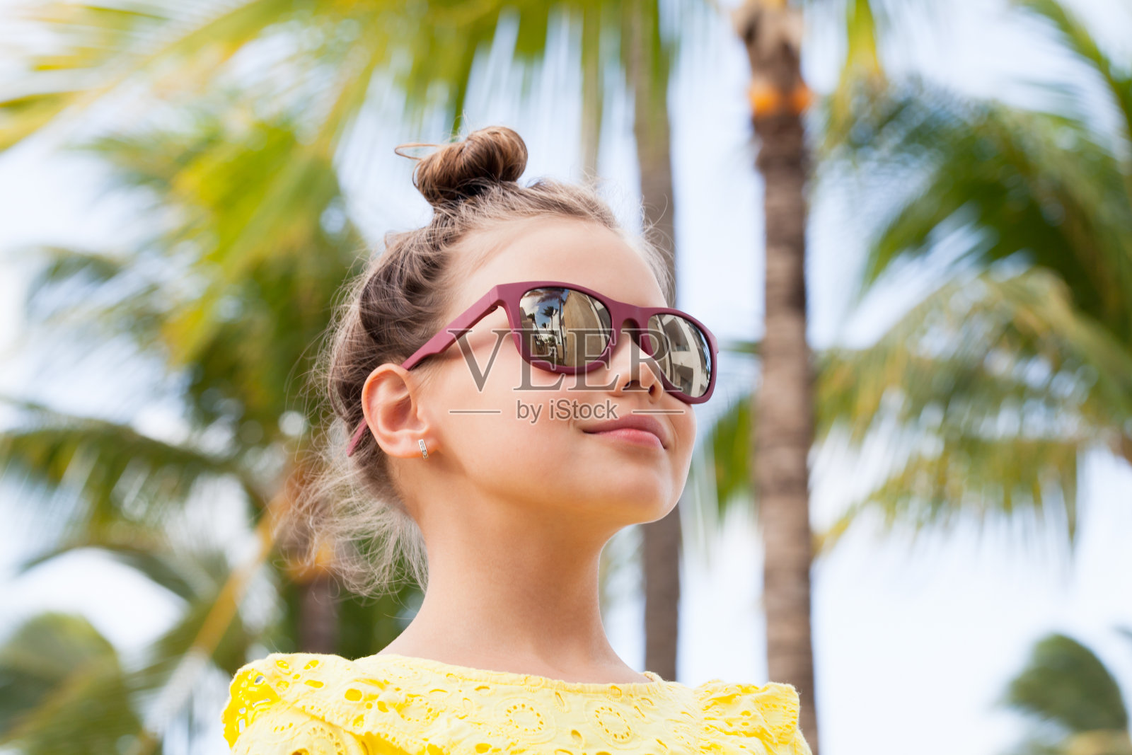 可爱的小女孩，穿着黄色的裙子，戴着墨镜照片摄影图片