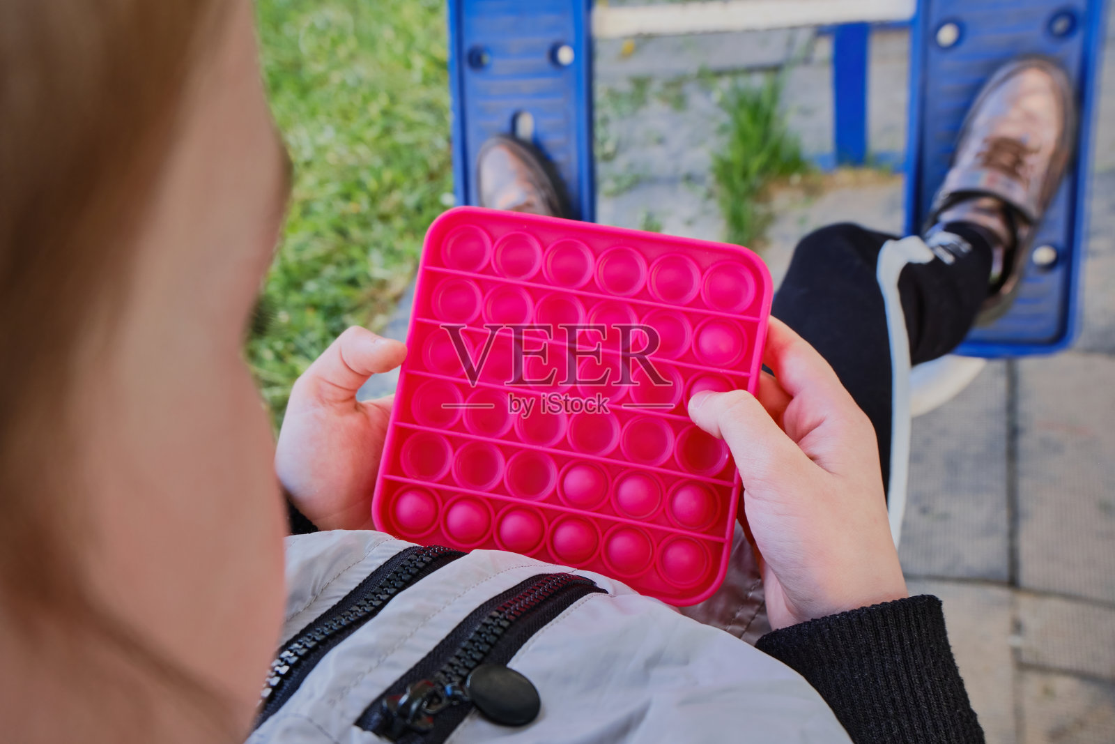 快乐有趣的小女孩玩pop，在模拟器上练习。一个七到九岁的小女孩手里。硅胶放松的玩具照片摄影图片