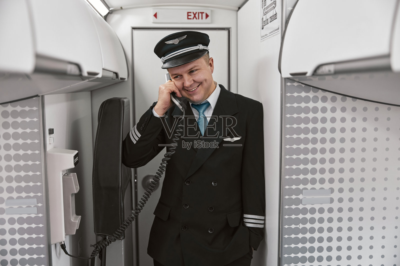 男飞行员在飞机上打电话照片摄影图片