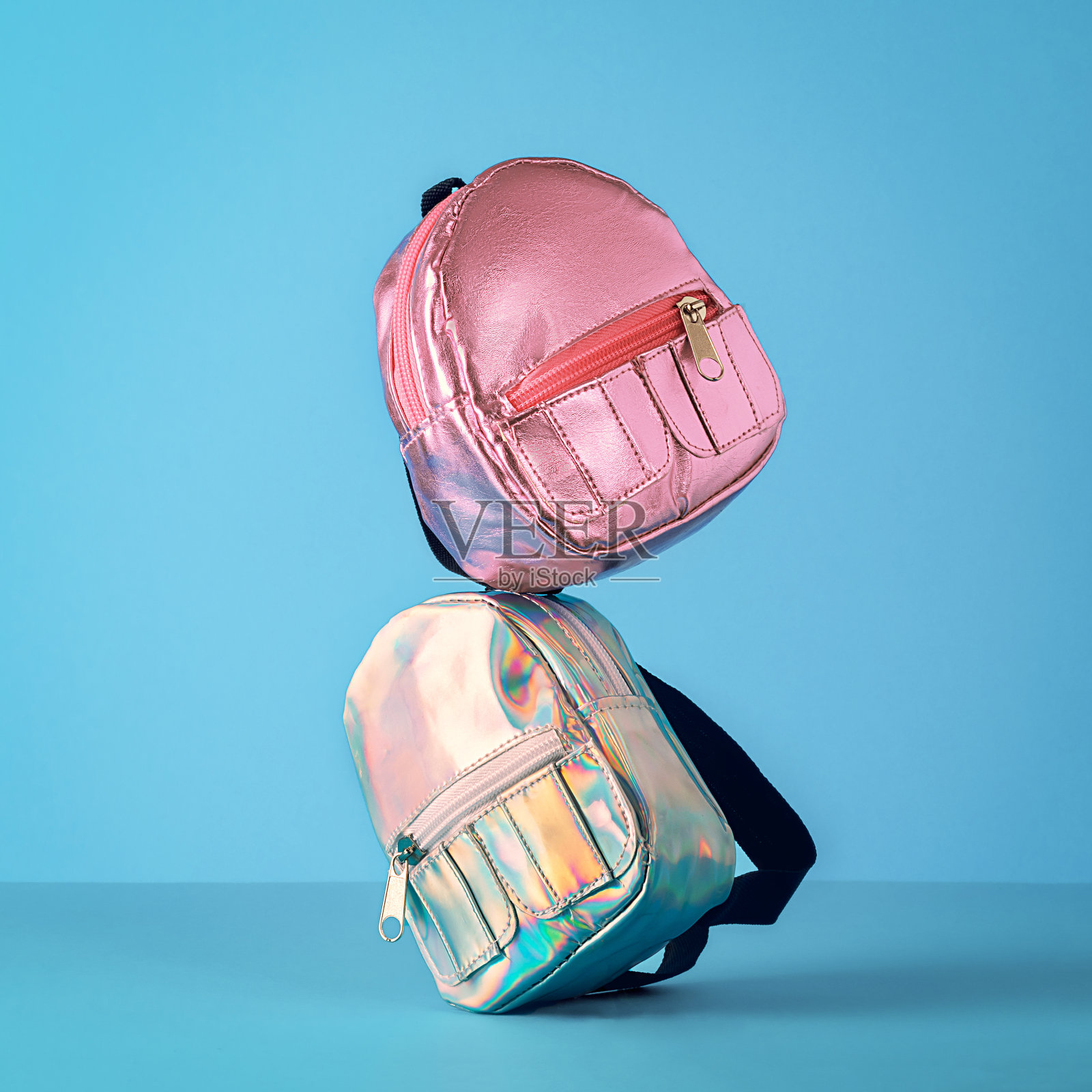 返校的创意理念。蓝色背景上平衡的书包。照片摄影图片