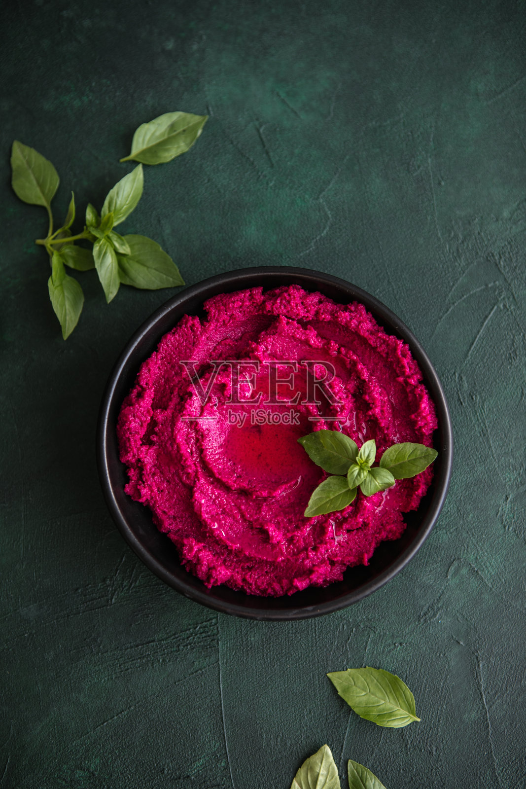 腐殖质碗。红甜菜根鹰嘴豆泥配新鲜蔬菜，桌上放橄榄油照片摄影图片