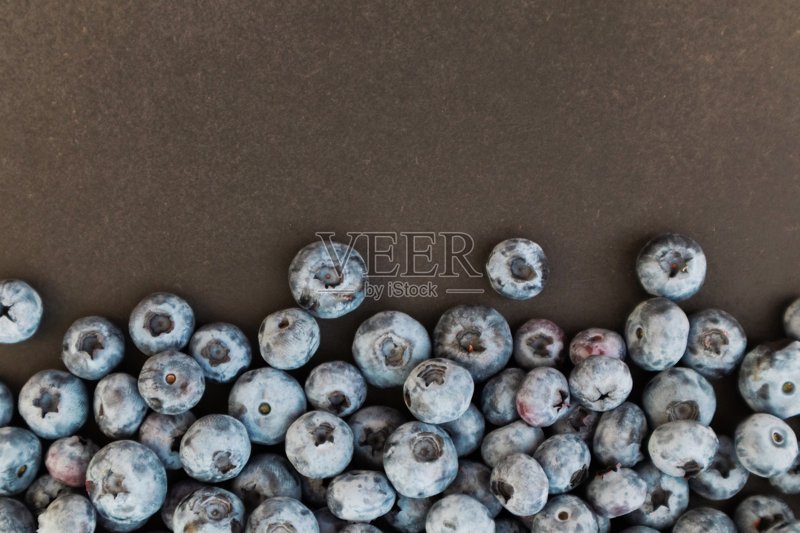 成熟的蓝莓在黑色的背景下美味可口。俯视图，乡村风格。照片摄影图片