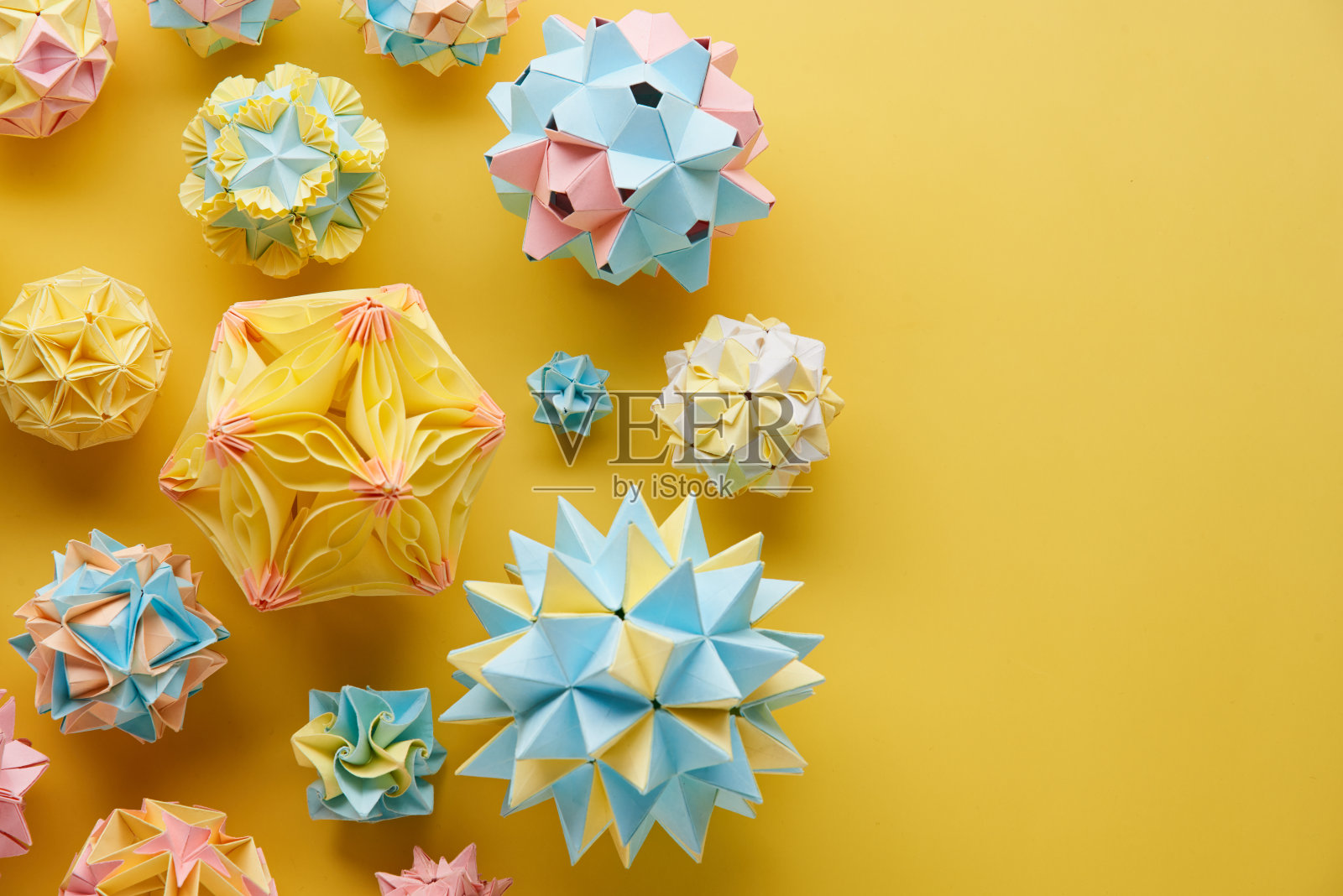 Set的multicolorÂ手工制作modularÂ折纸球或Kusudama孤立在黄色背景。视觉艺术，几何学，折纸艺术，纸工艺品。俯视图，特写，选择性聚焦，复制空间。照片摄影图片