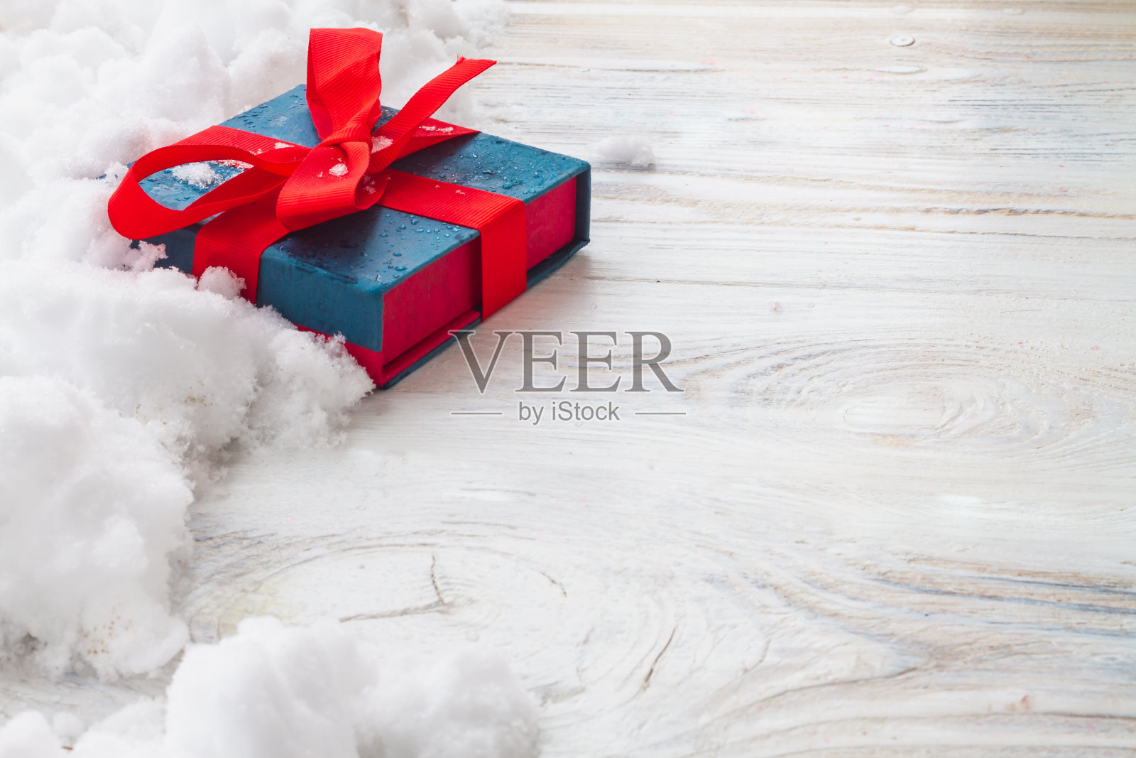 一份圣诞礼物装在白色背景的盒子里，上面有雪花和圣诞树的树枝。本空间照片摄影图片