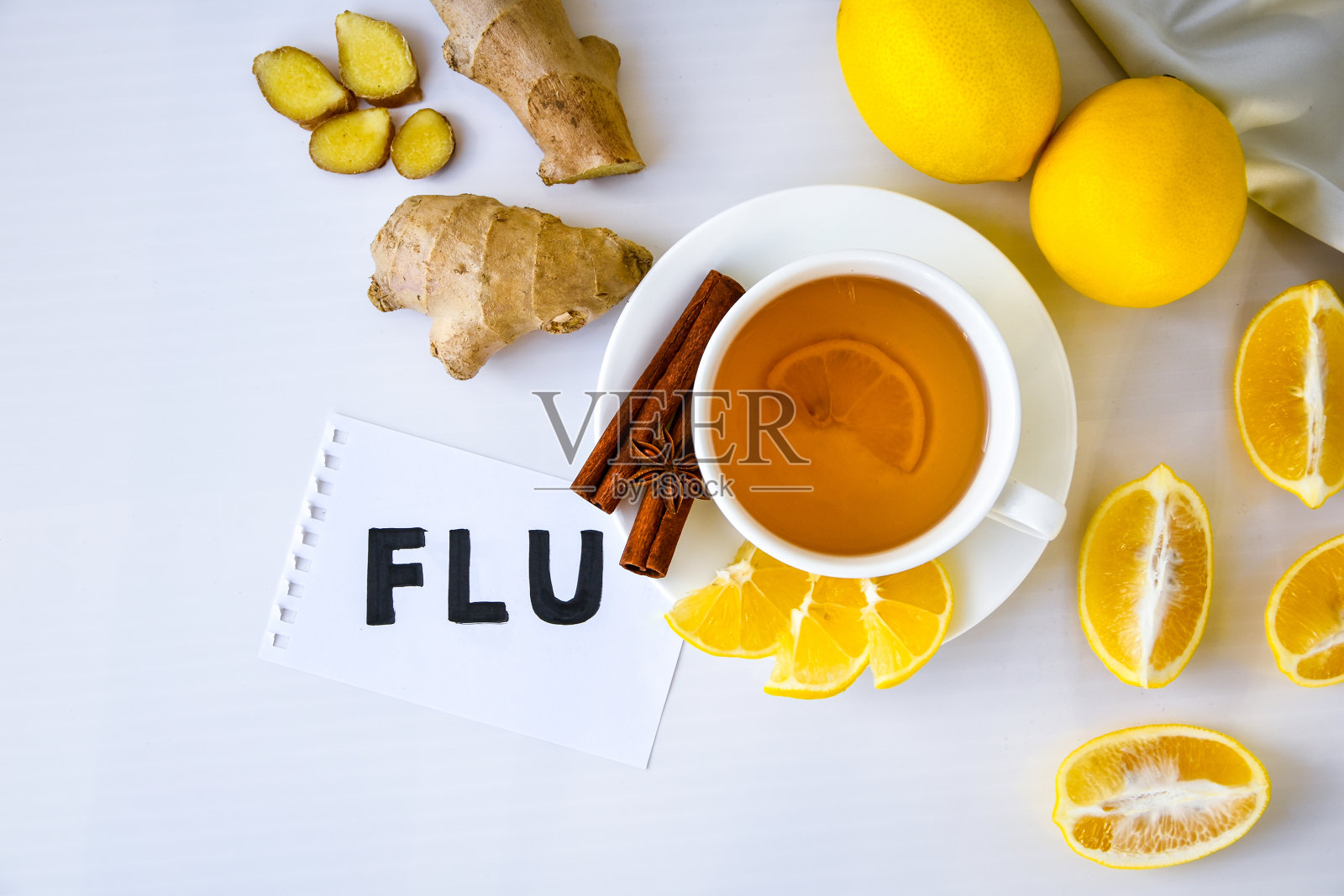 感冒——写在纸上的治疗普通感冒的产品——柠檬、生姜、甘菊茶。天然维生素饮料照片摄影图片