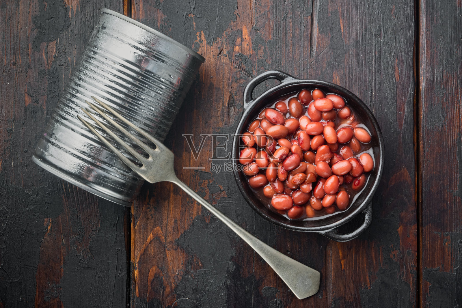 日本罐装食品配料，甜红豆，放在旧的深色木桌背景上，俯视图平摆照片摄影图片