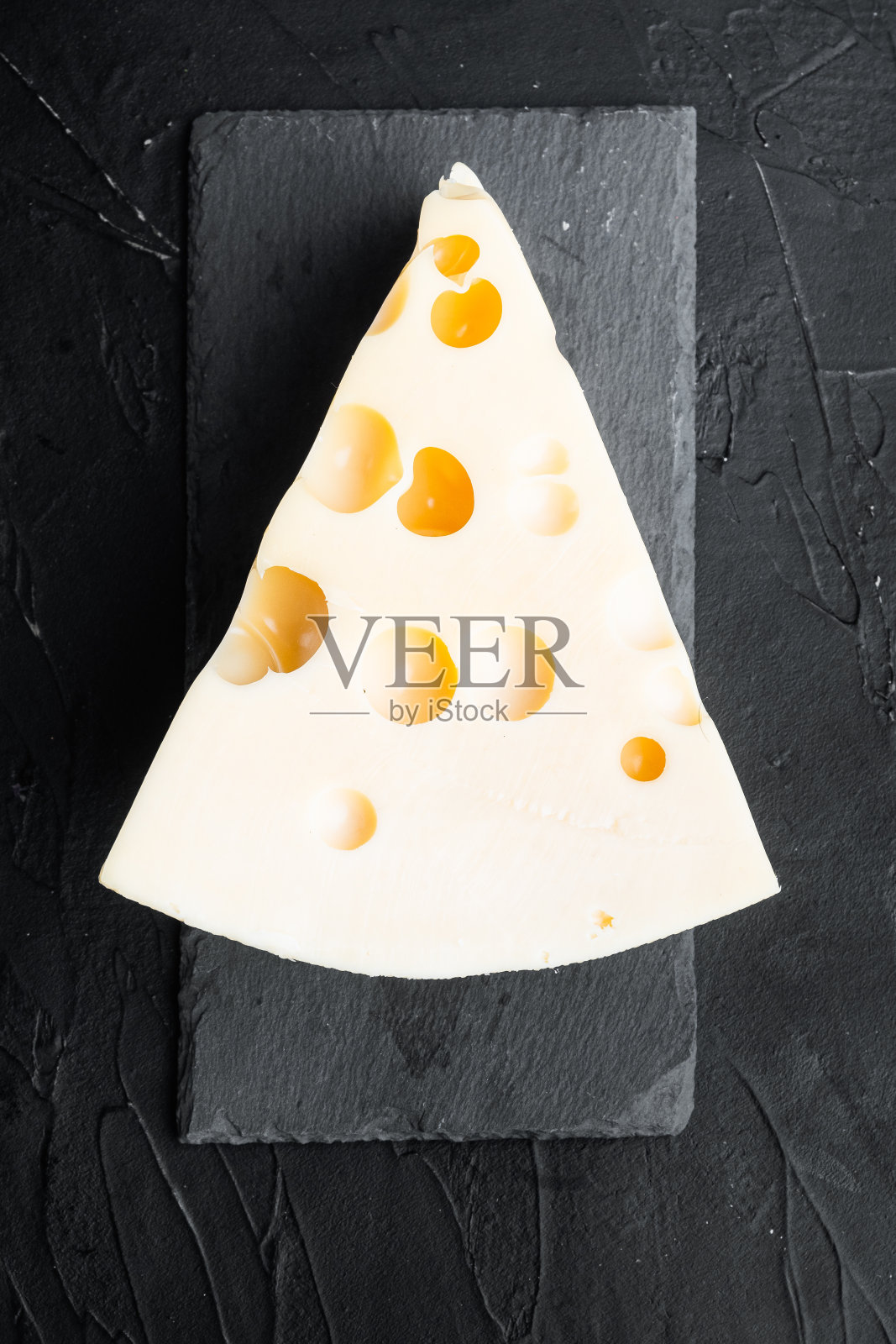 Maasdam奶酪，黑色石头背景，俯视图平躺照片摄影图片