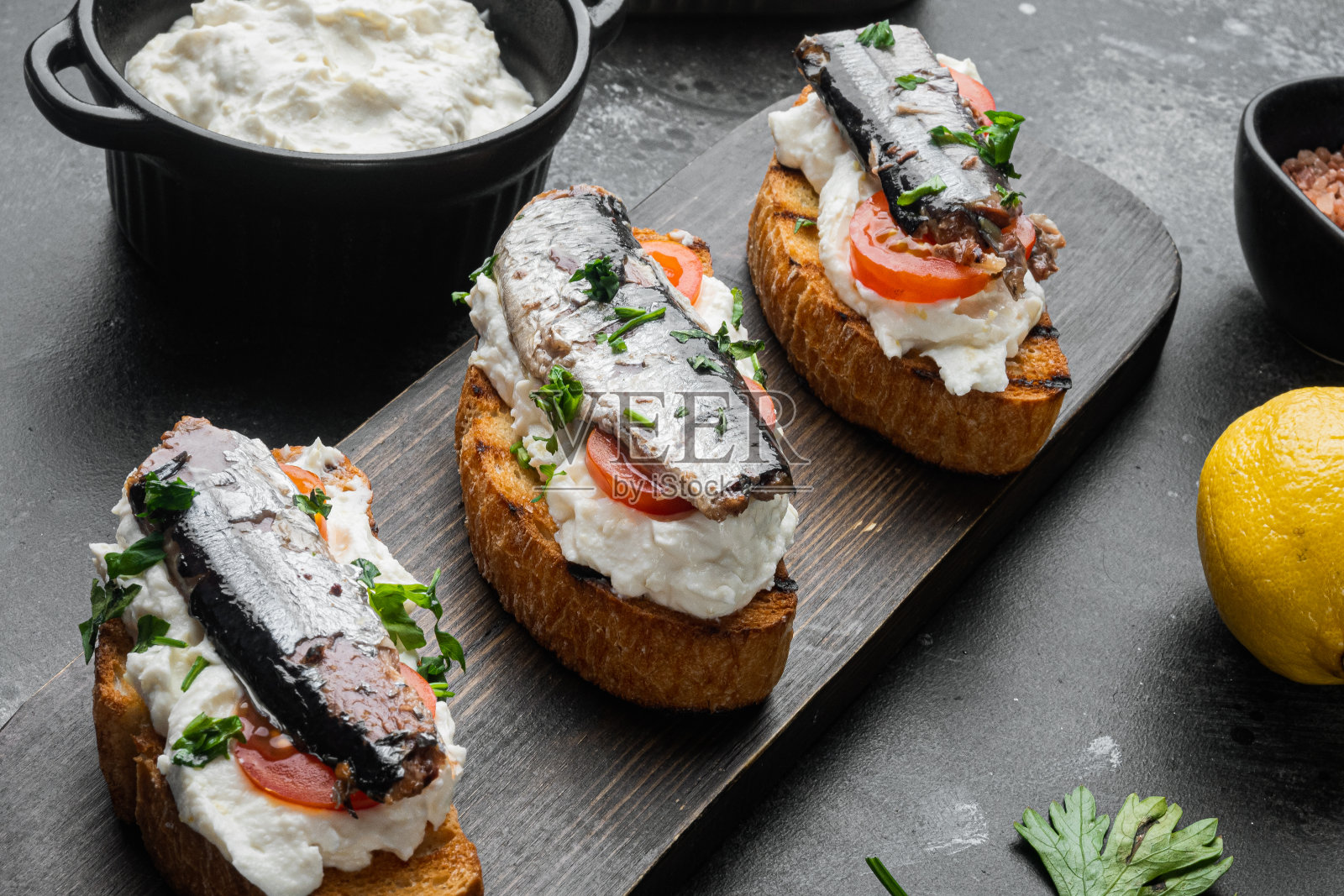 意大利干酪沙丁鱼吐司，在黑色的石头背景照片摄影图片