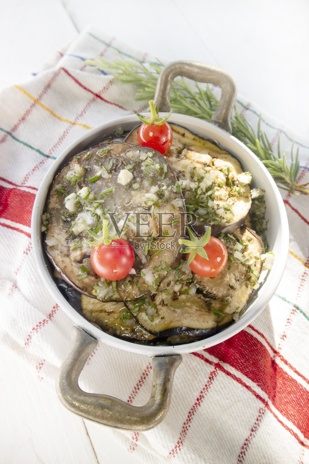 在一个小圆锅里烤茄子和圣女果照片摄影图片