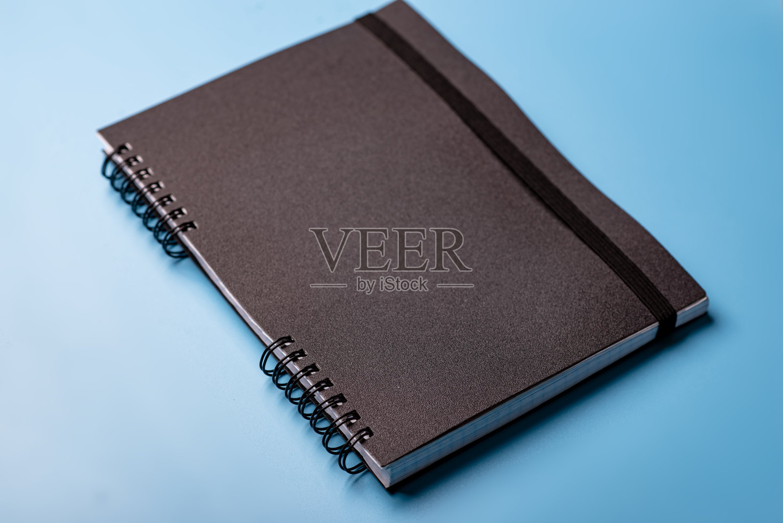 蓝色背景上的黑色笔记本。培训、日记的概念。照片摄影图片