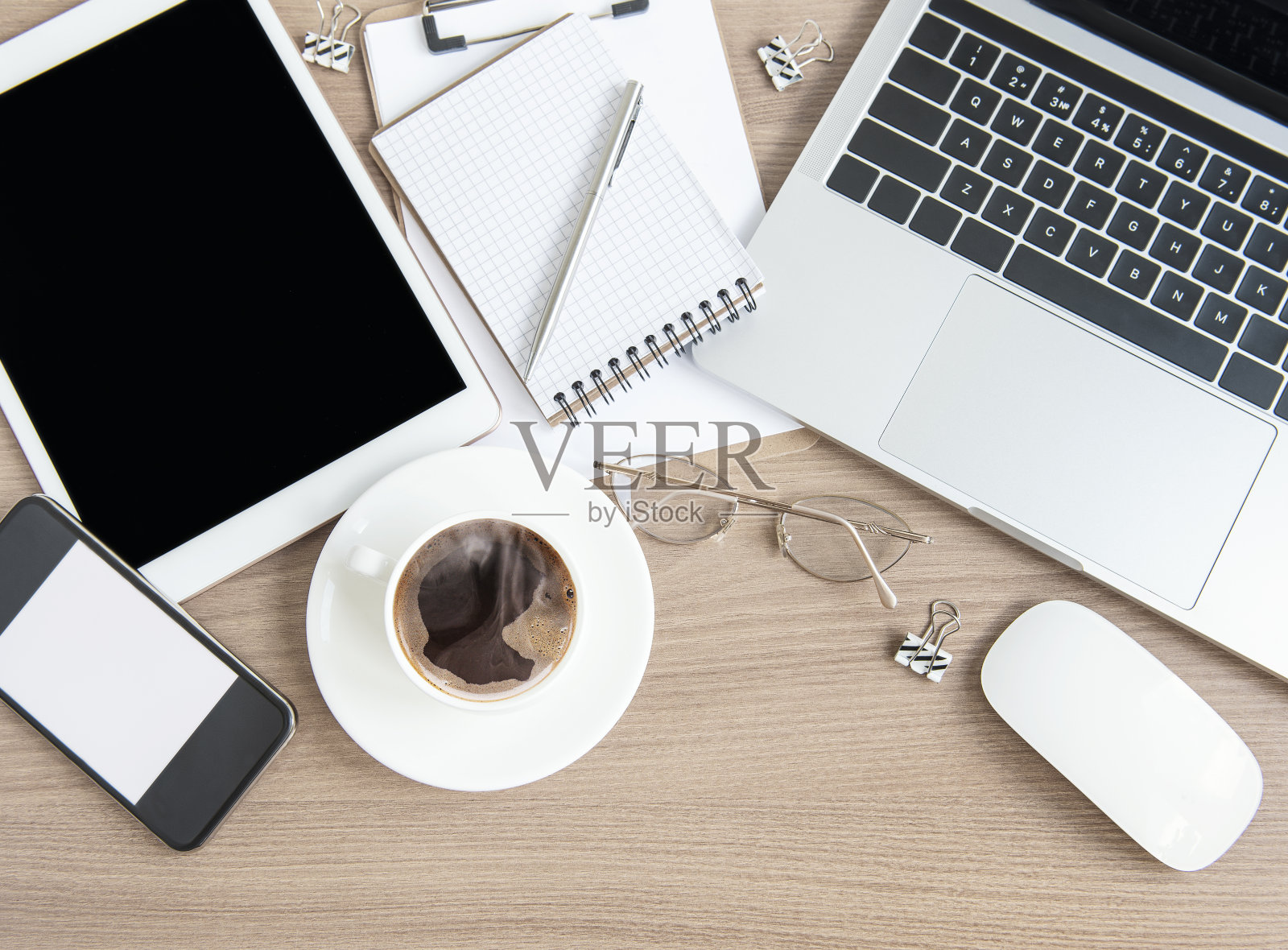 桌上放有办公用品和咖啡的笔记本电脑。照片摄影图片