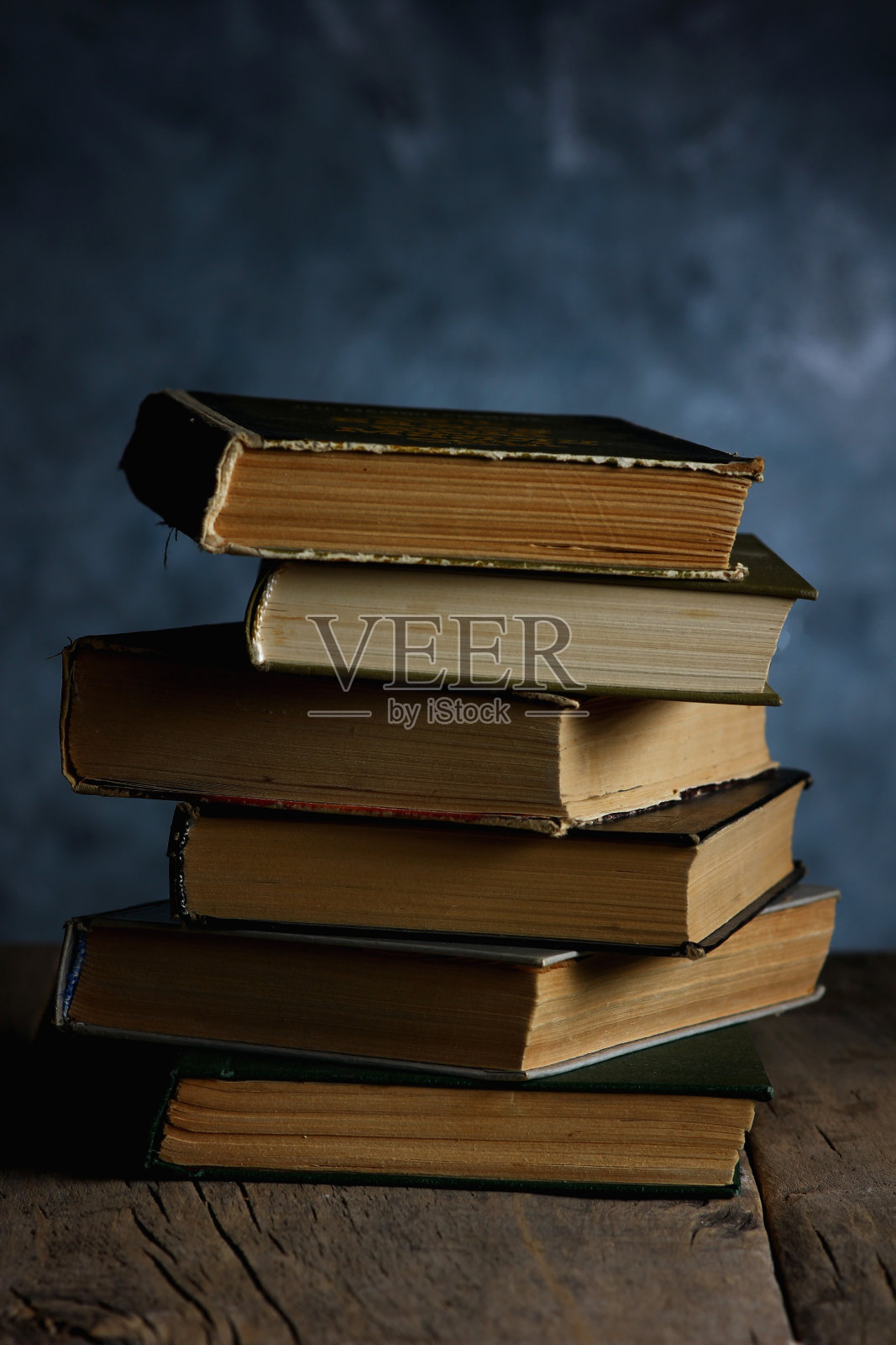 可供阅读的书籍堆放在一张用旧木头制成的有纹理的桌子上照片摄影图片