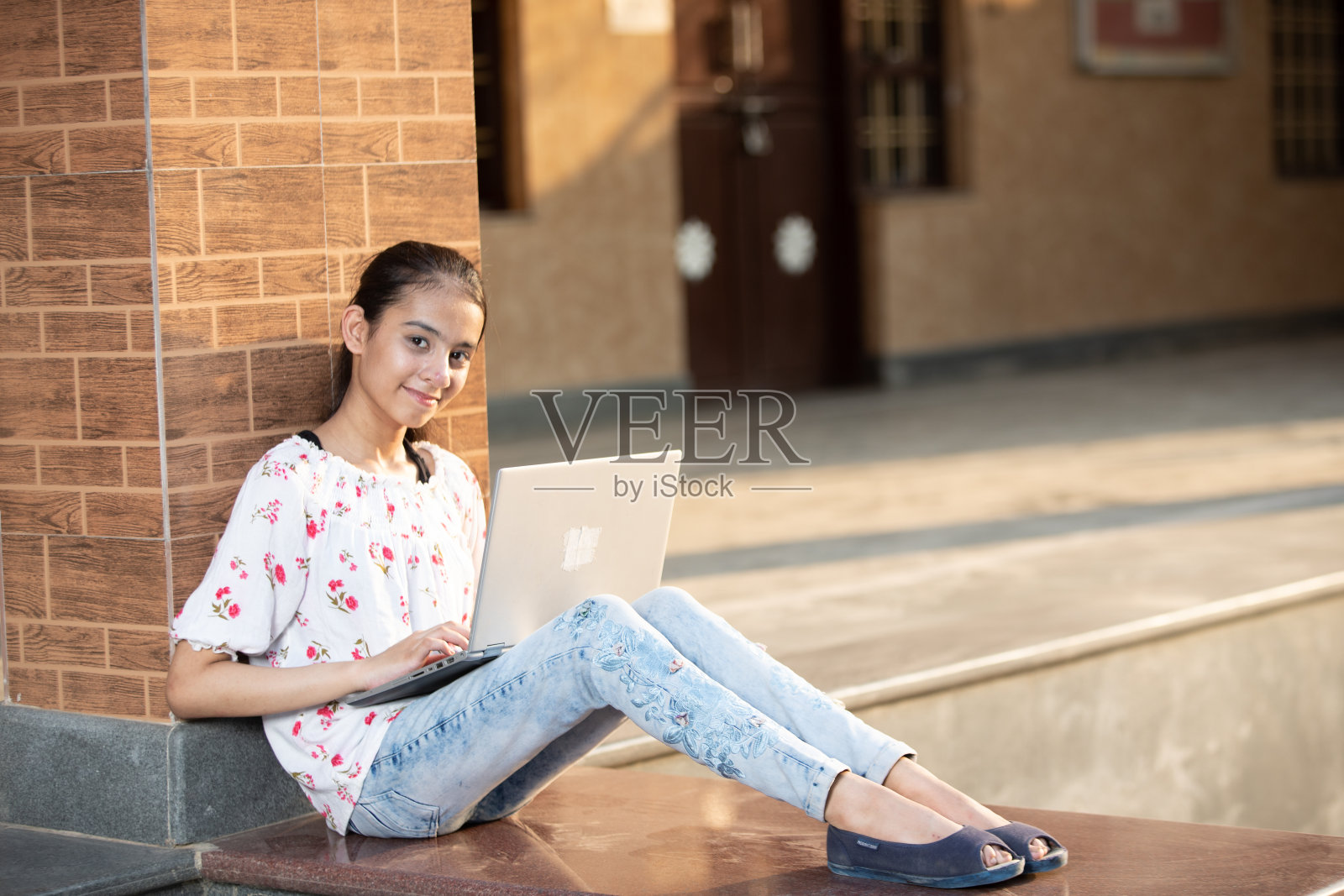 年轻女孩在校园里用笔记本电脑看镜头照片摄影图片