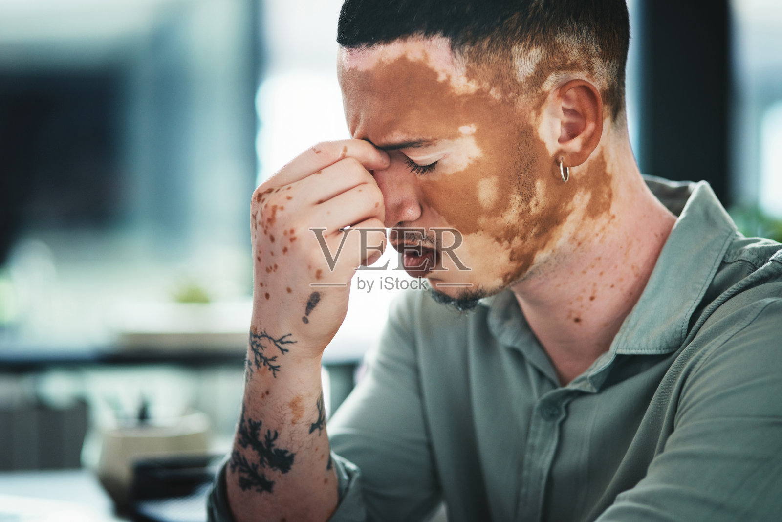 一名年轻的商人在办公室里与头痛作斗争照片摄影图片