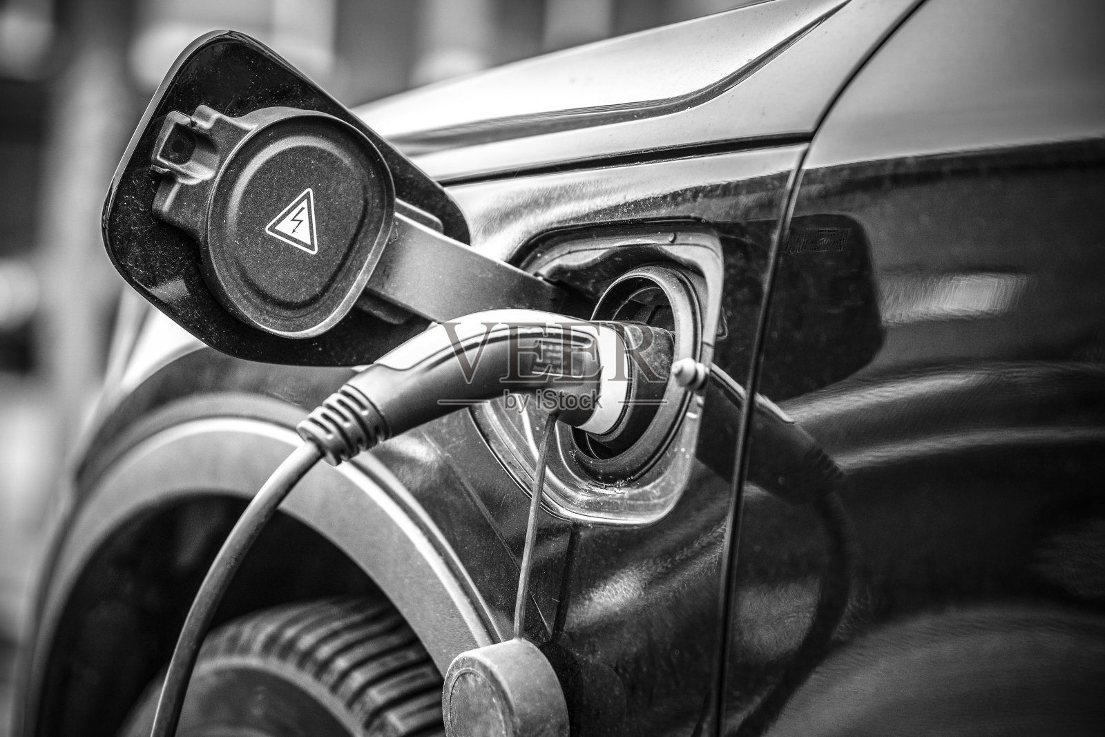 电子充电器插在混合动力汽车充电过程中照片摄影图片