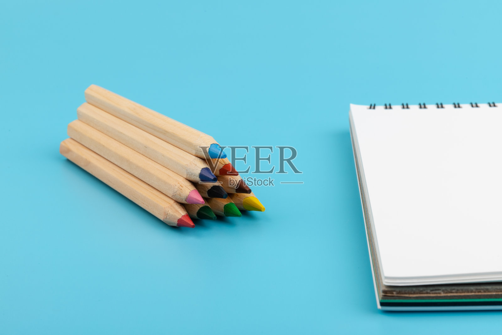 白纸和蓝色背景上的彩色铅笔照片摄影图片