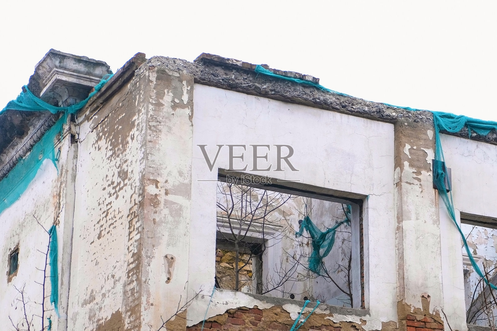 被摧毁的建筑，年久失修的房屋，被拆除的老房子以灰色的天空为背景。照片摄影图片