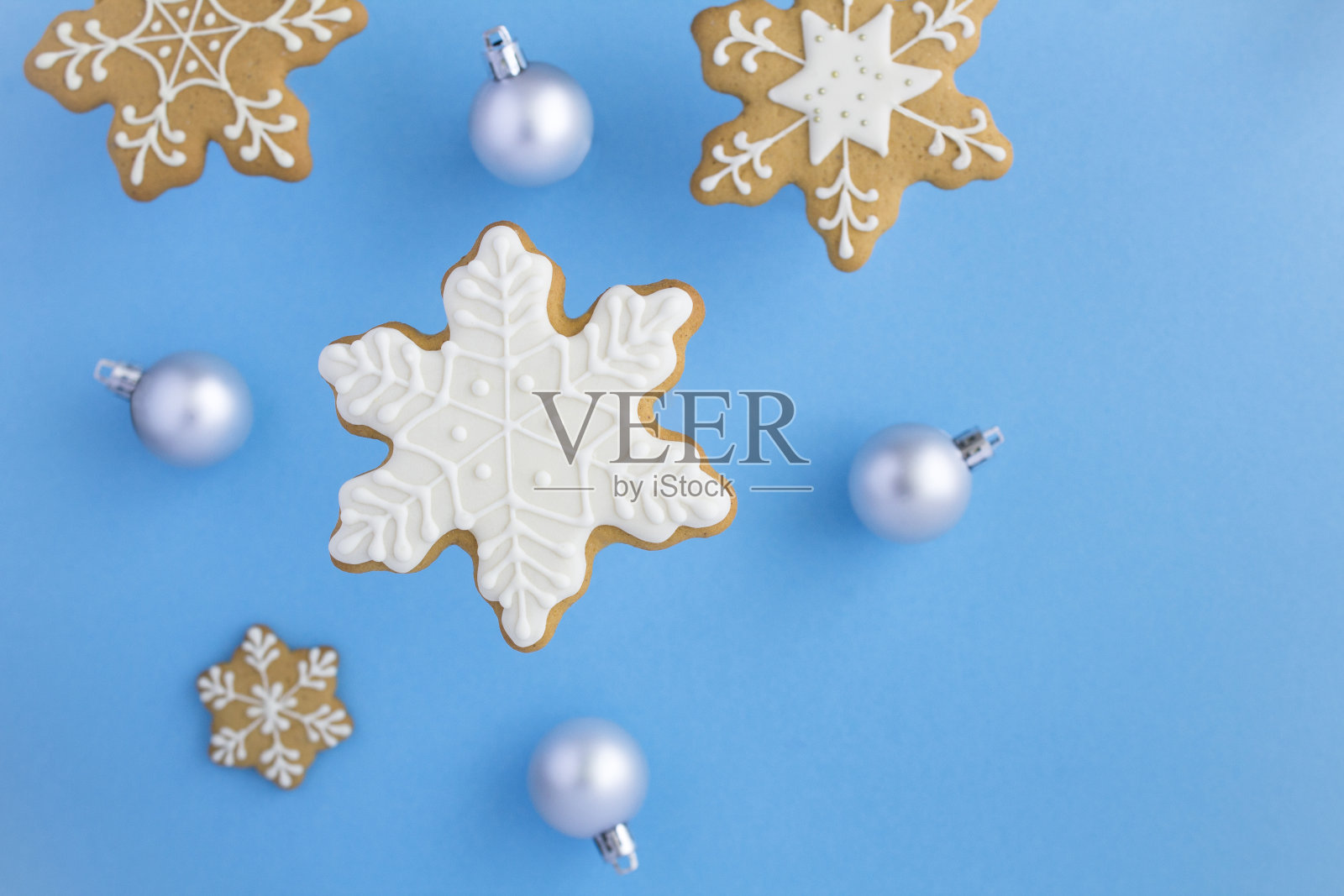 顶部视图的圣诞雪花形状的姜饼在蓝色的背景照片摄影图片