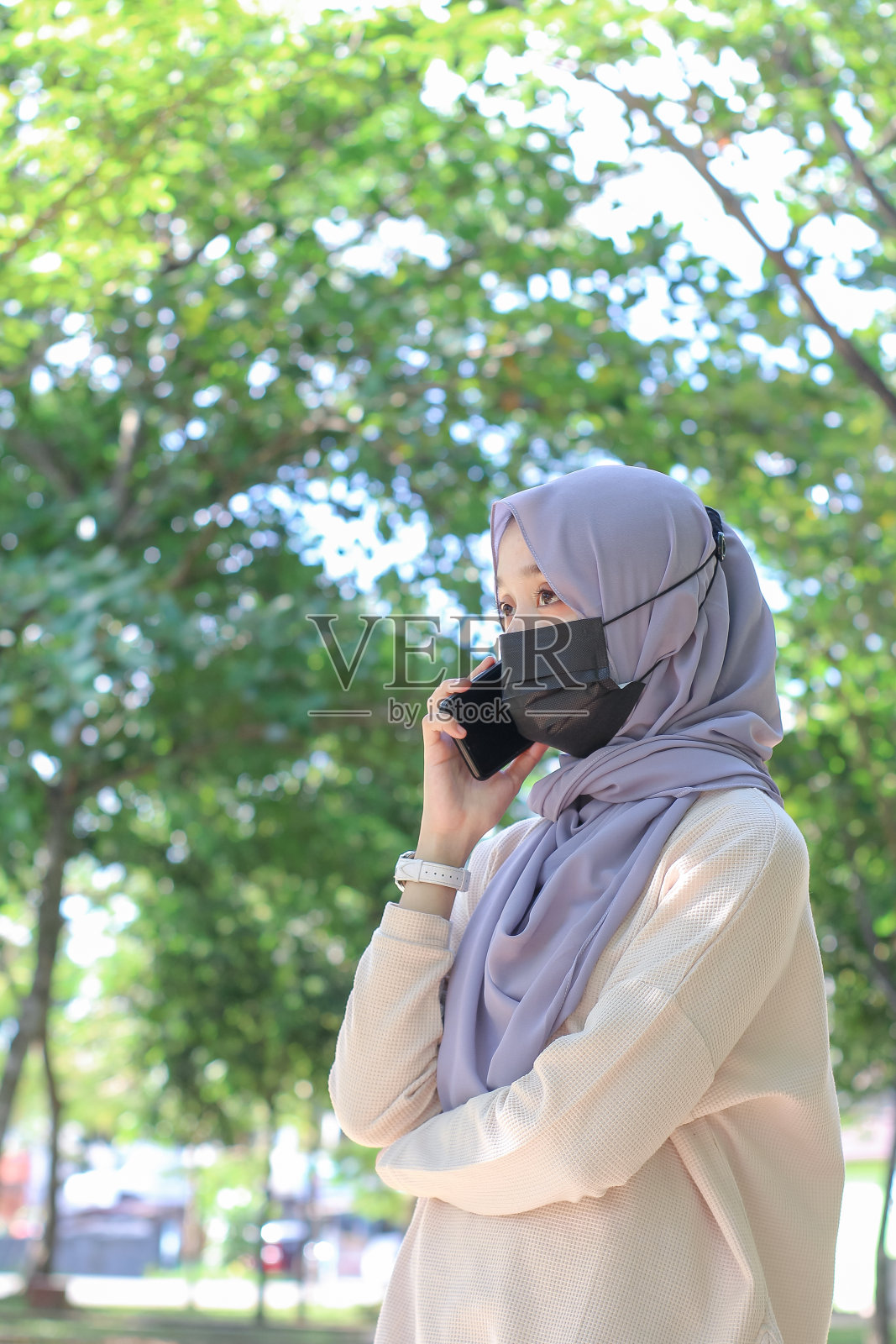 亚洲年轻女性在公园里打电话照片摄影图片