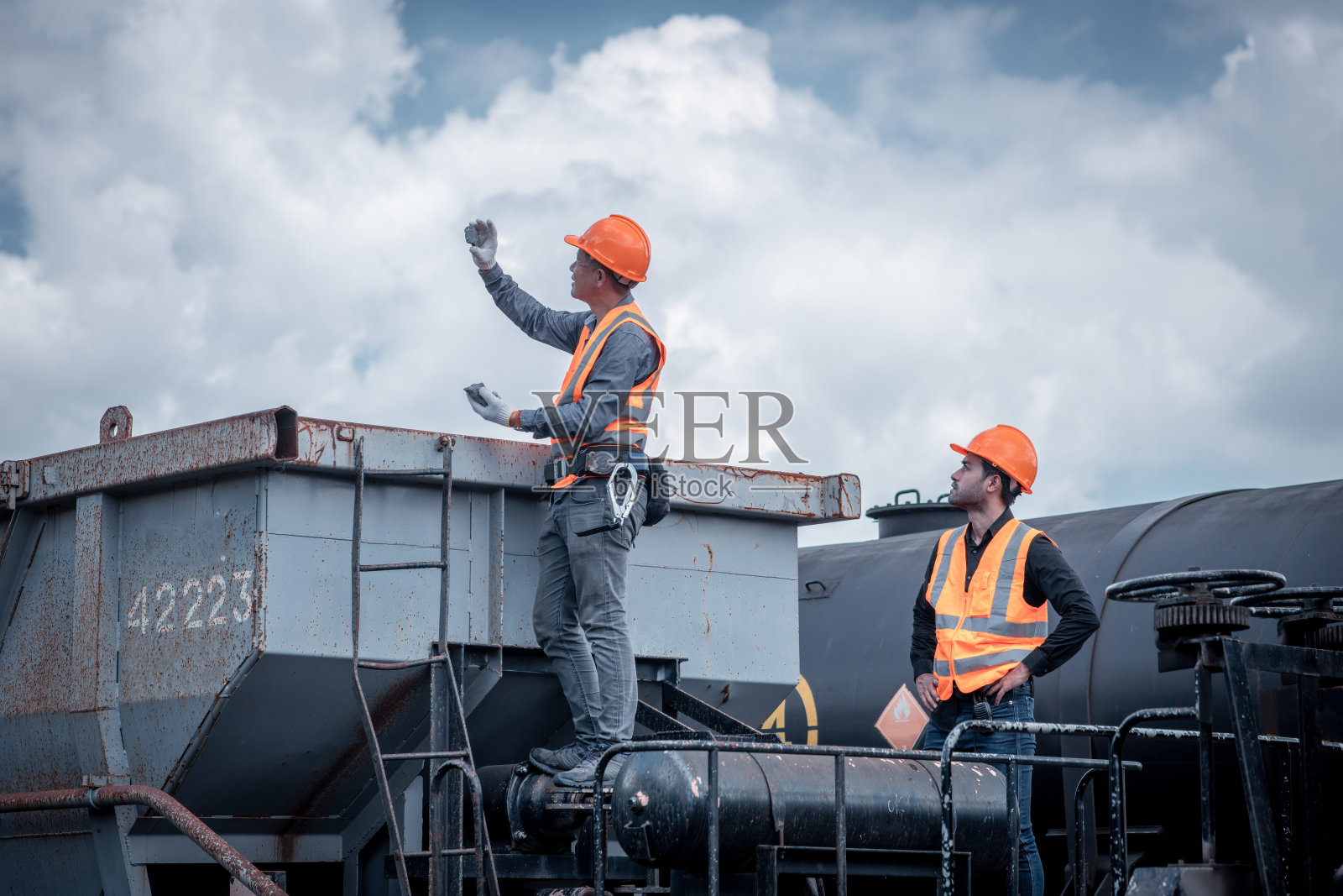 讨论工程师检查和检查施工过程，铁路转轨和车站的检查工作。工程师在工作中穿着安全制服和安全帽。照片摄影图片