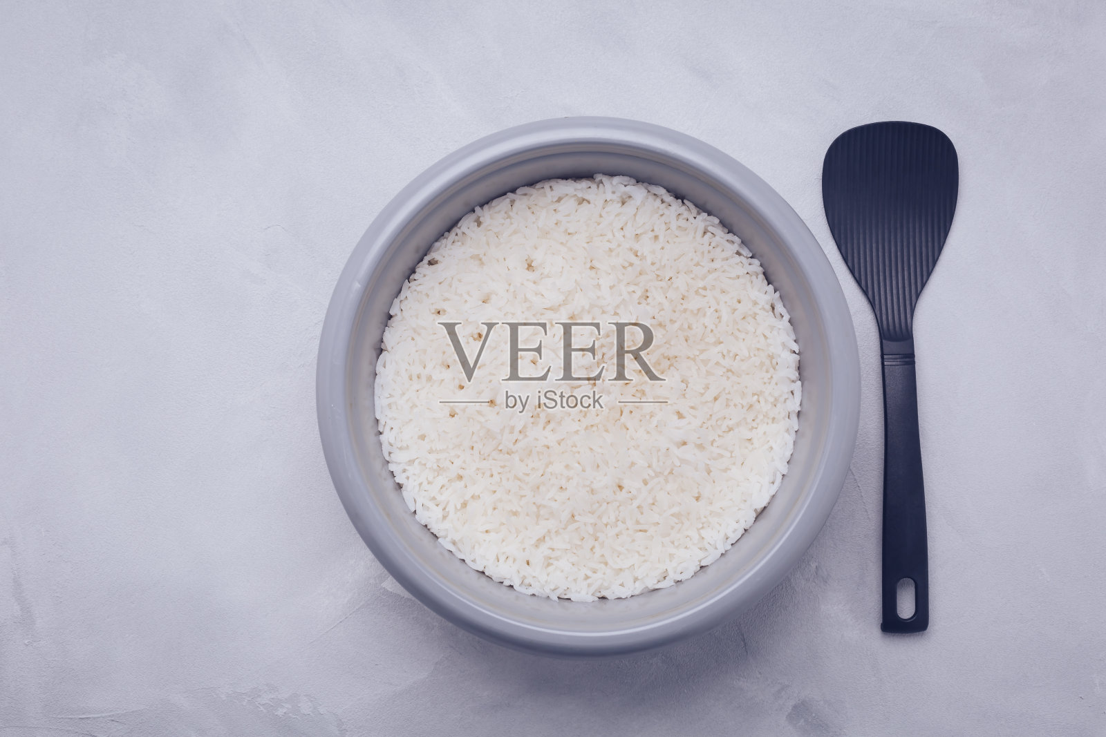 米饭在电饭锅或蒸笼用勺子，俯视图照片摄影图片